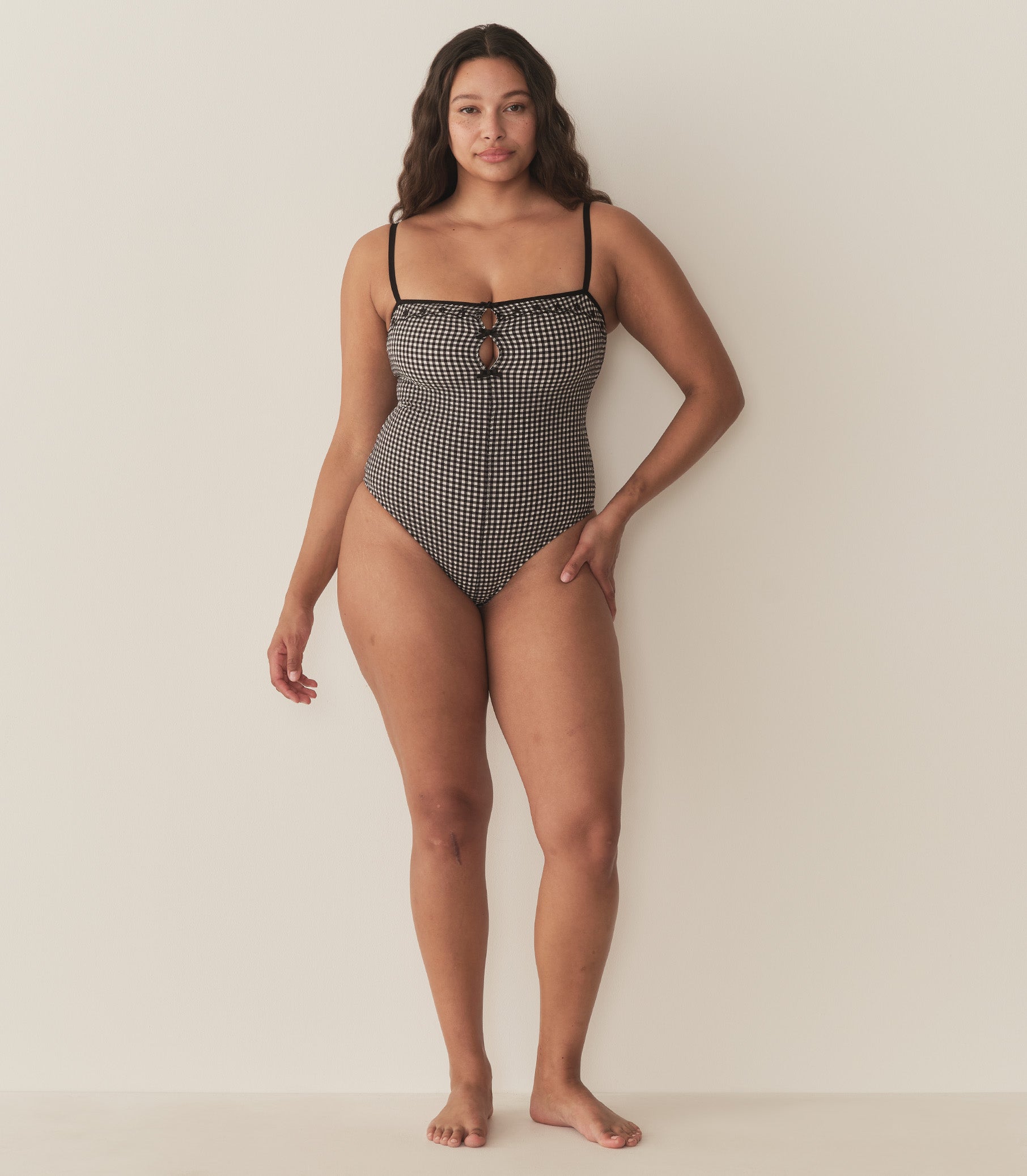 Alana is wearing a black and white gingham one piece swimsuit. 5