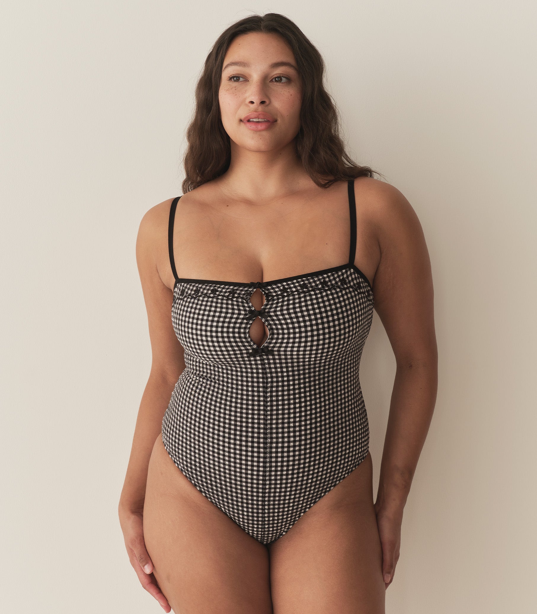 Alana is wearing a black and white gingham one piece swimsuit. 4