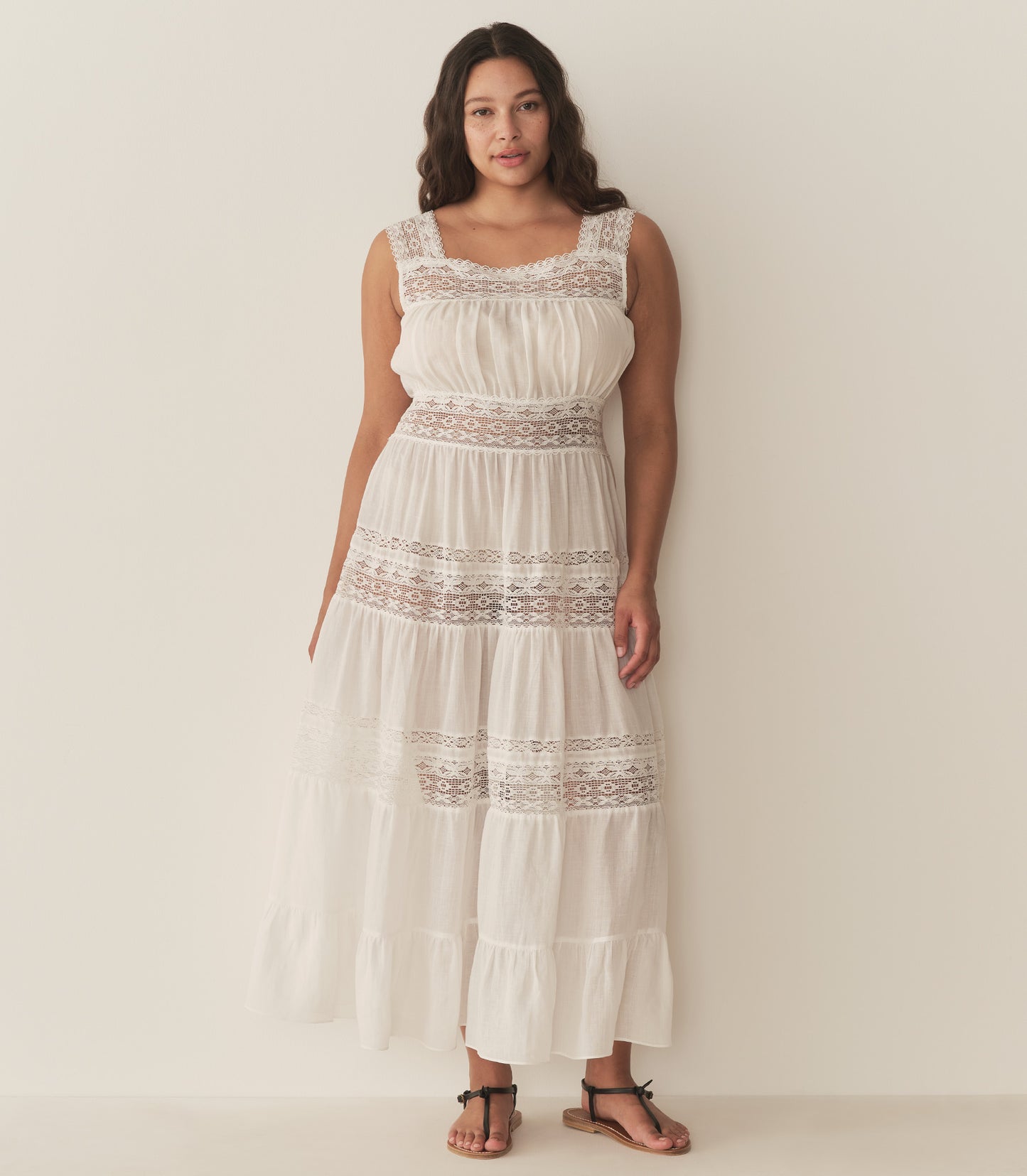 Alana is wearing a long white sleeveless dress.