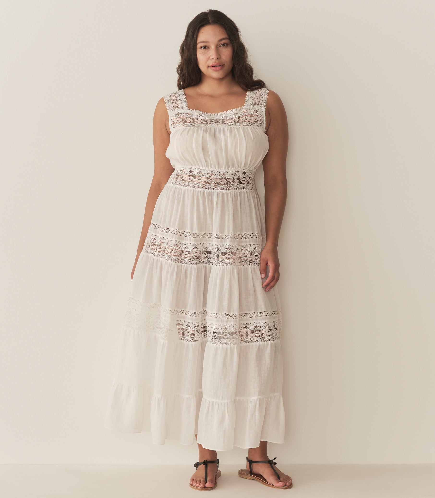 Alana is wearing a long white sleeveless dress. 9