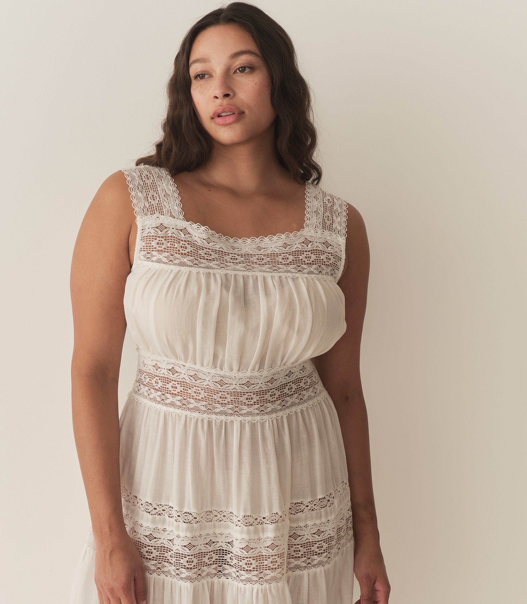 Alana is wearing a long white sleeveless dress. 8