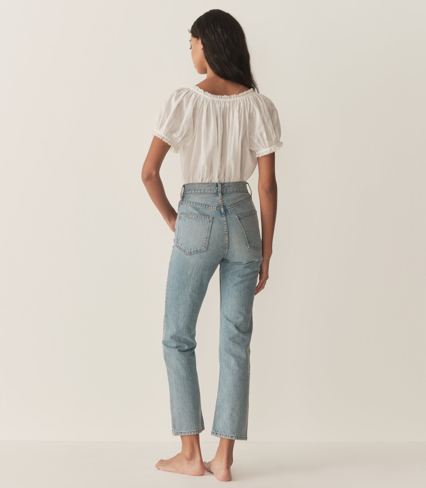 Rocio is wearing a white short puff sleeve blouse and denim jeans.