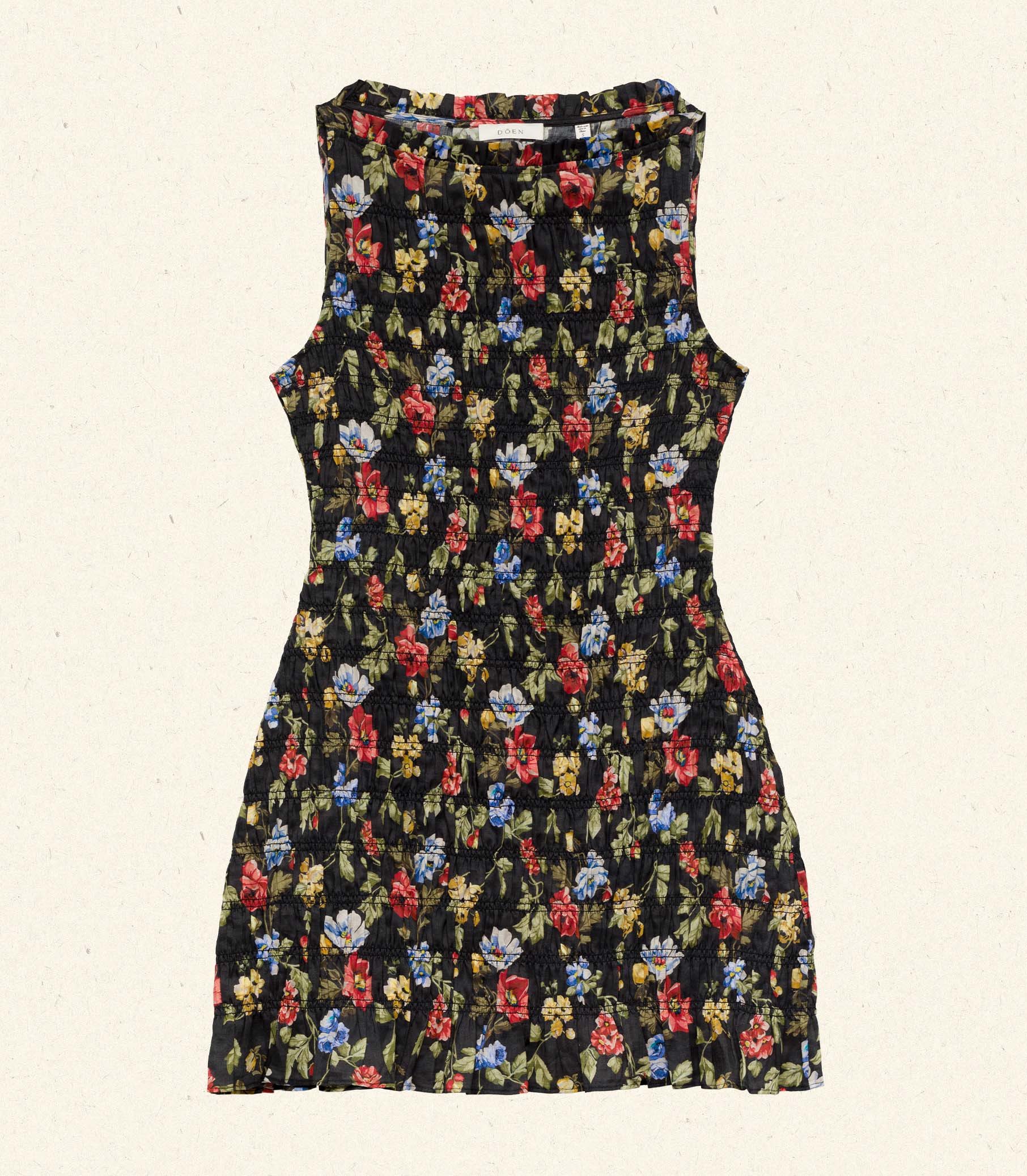 Melodie is wearing a black floral mini dress in front of a rustic background. 5