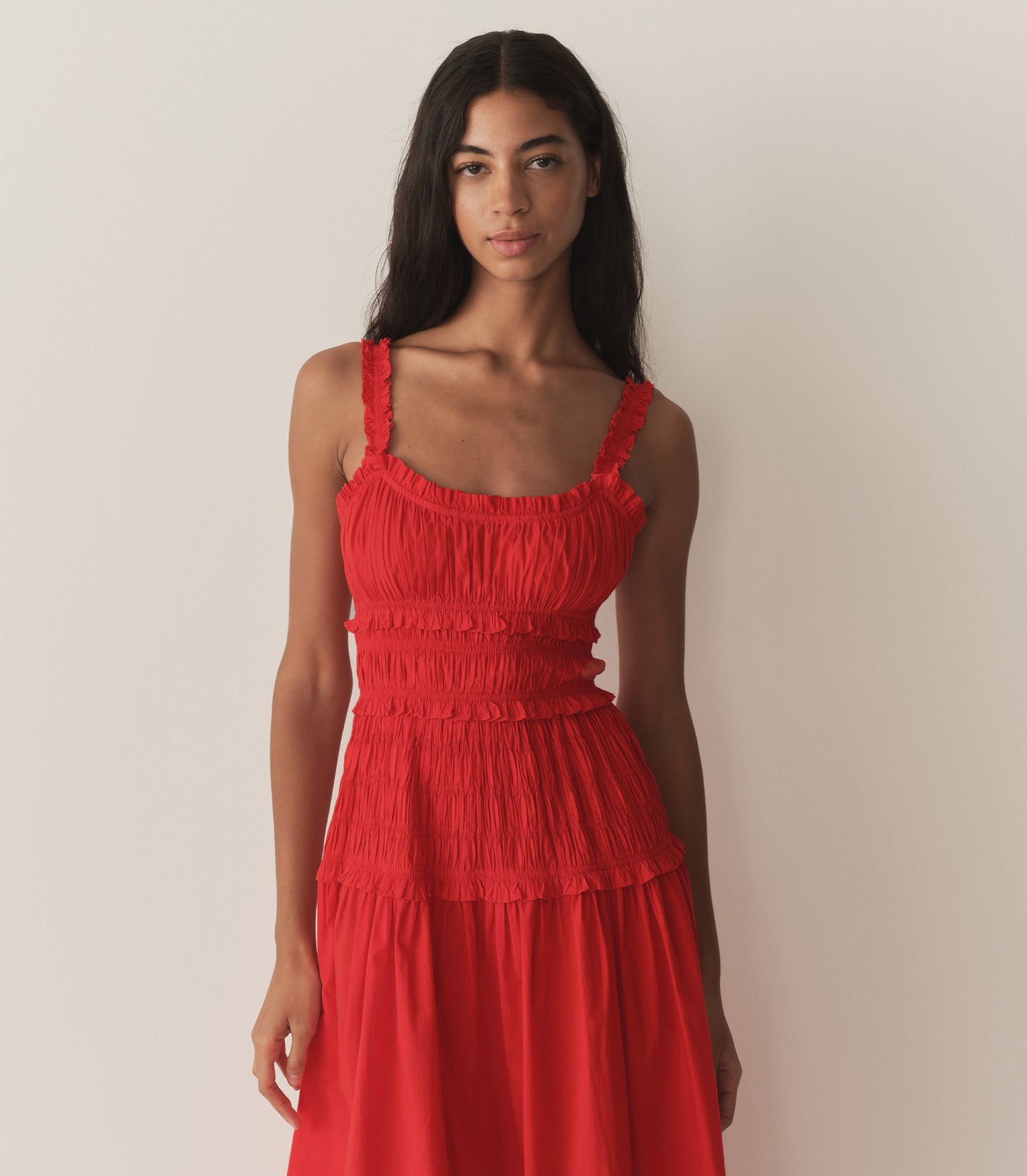Rocio is wearing a red mid-length dress with sandals.