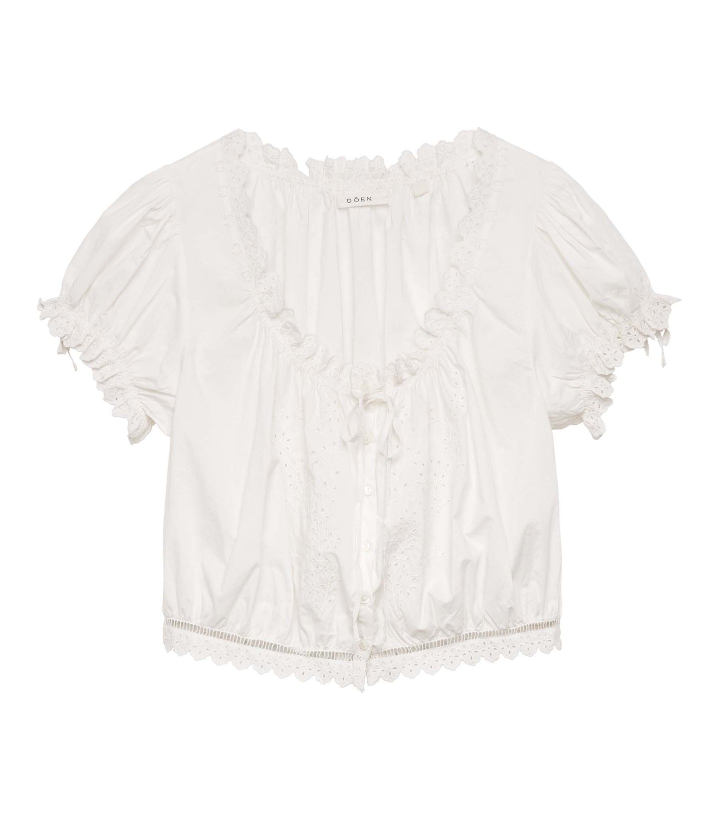 Rocio is wearing a white short puff sleeve top with white pants and yellow mule heels.