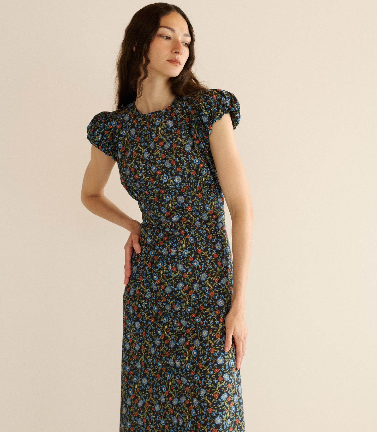 Woman wearing a floral dress against a beige background