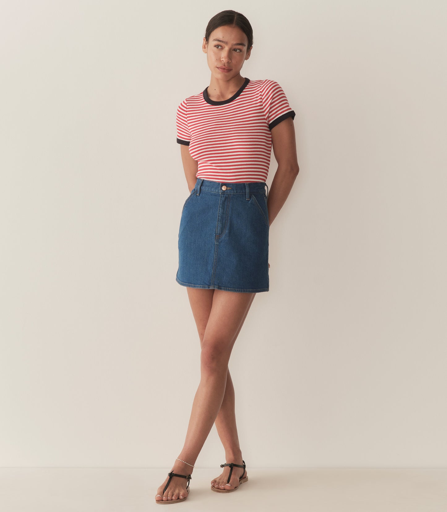 Zahara is wearing a denim A-Line skirt paired with a striped top.