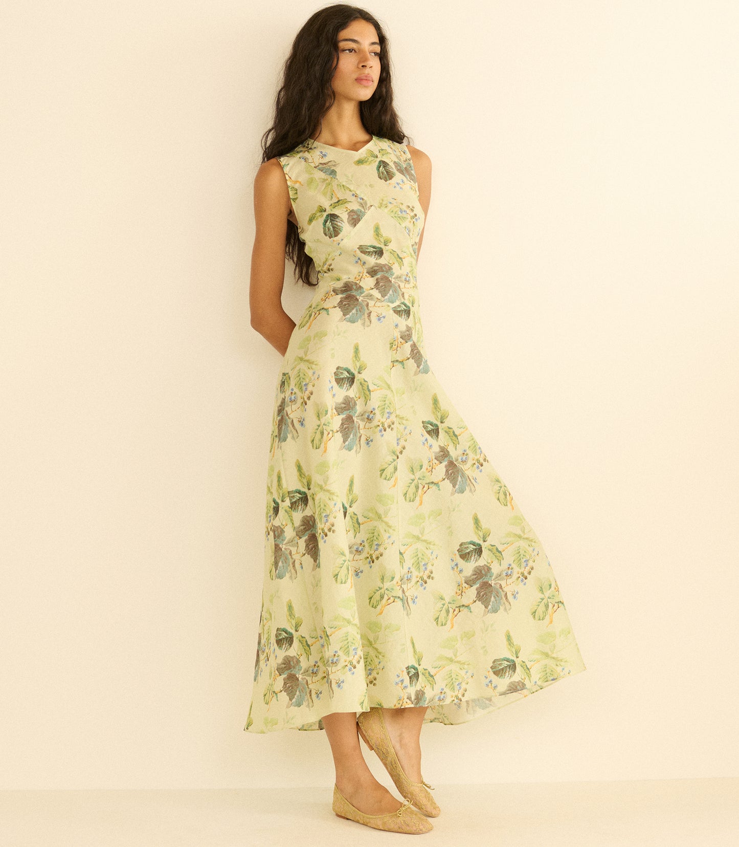 Woman wearing a floral dress against a plain background
