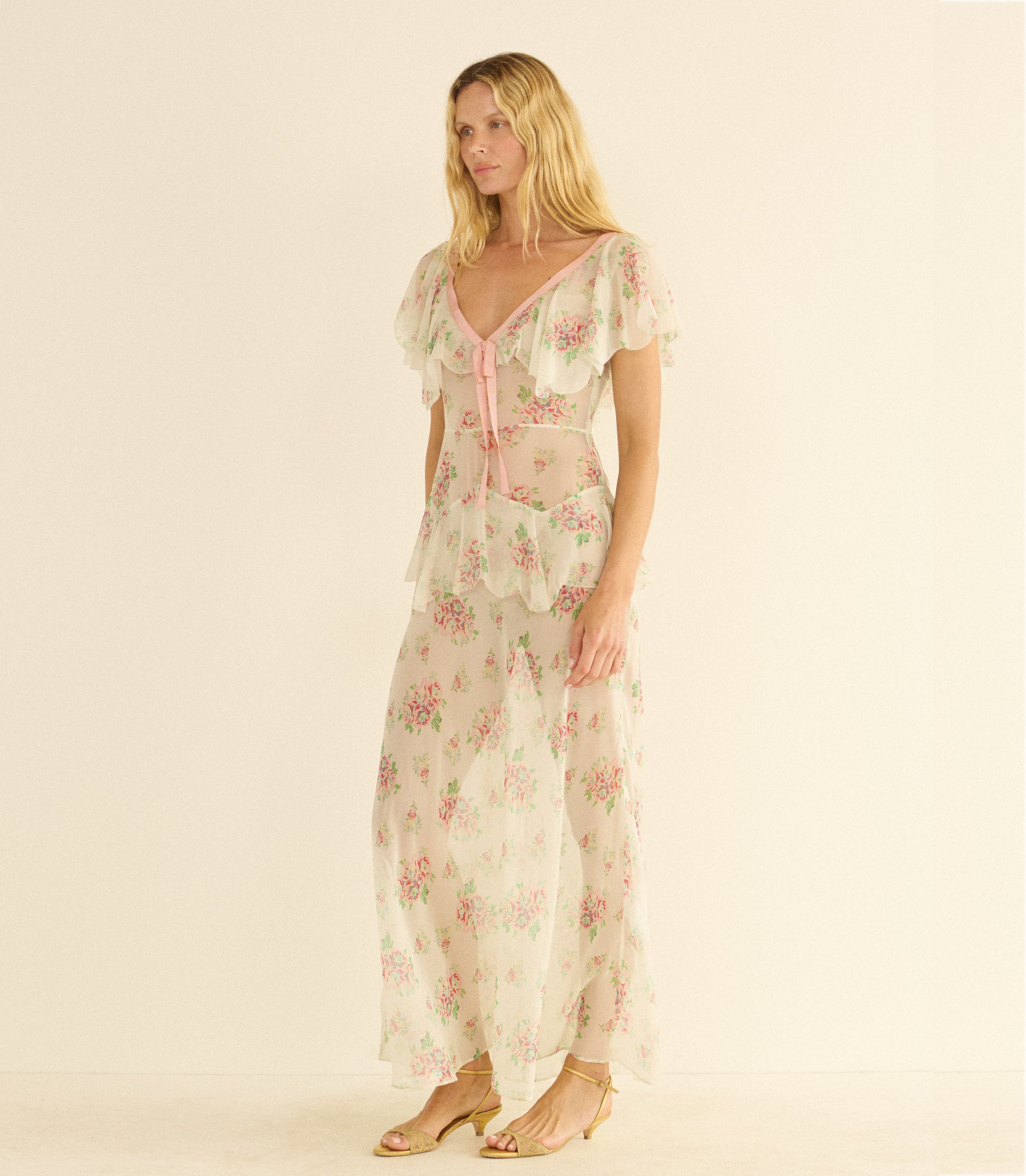 Woman wearing a white floral dress on a beige background 1

