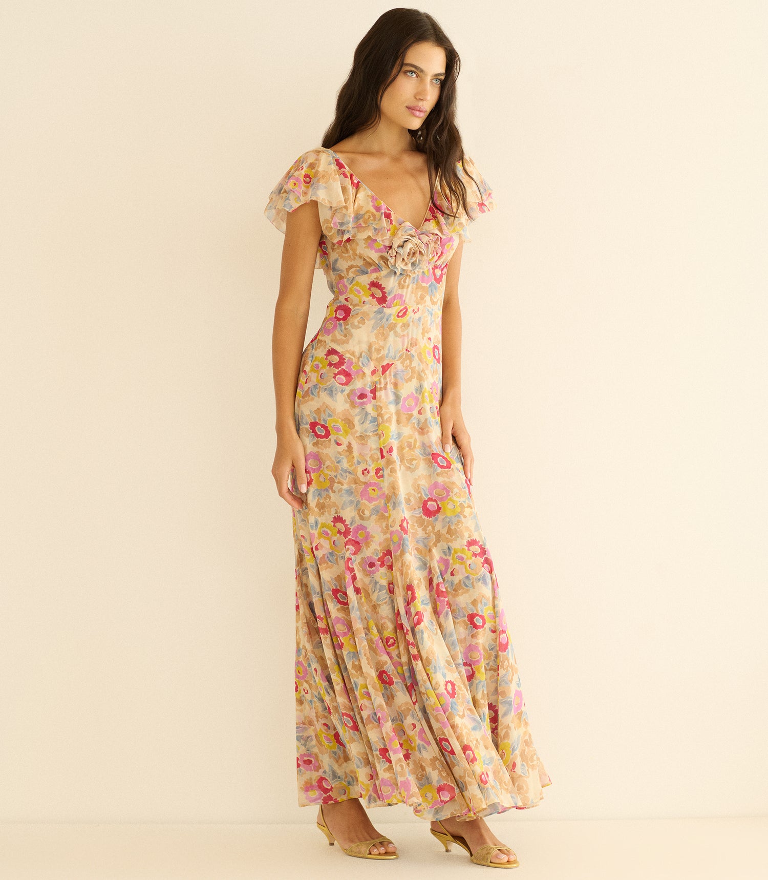 Woman wearing a long floral dress on a beige background