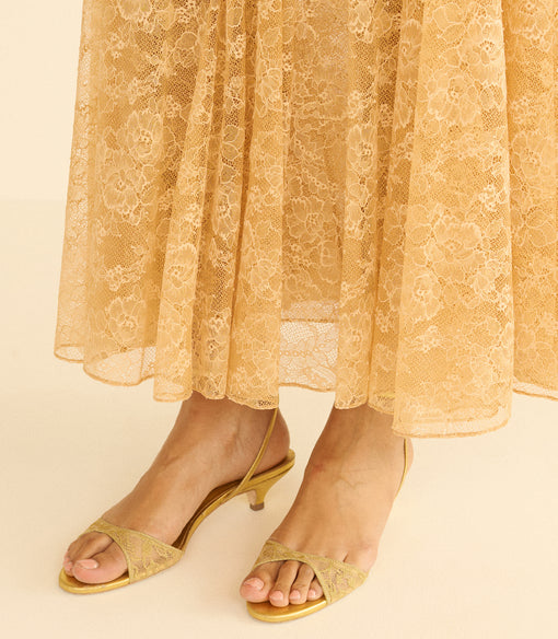 Gold lace sandals on a beige background
