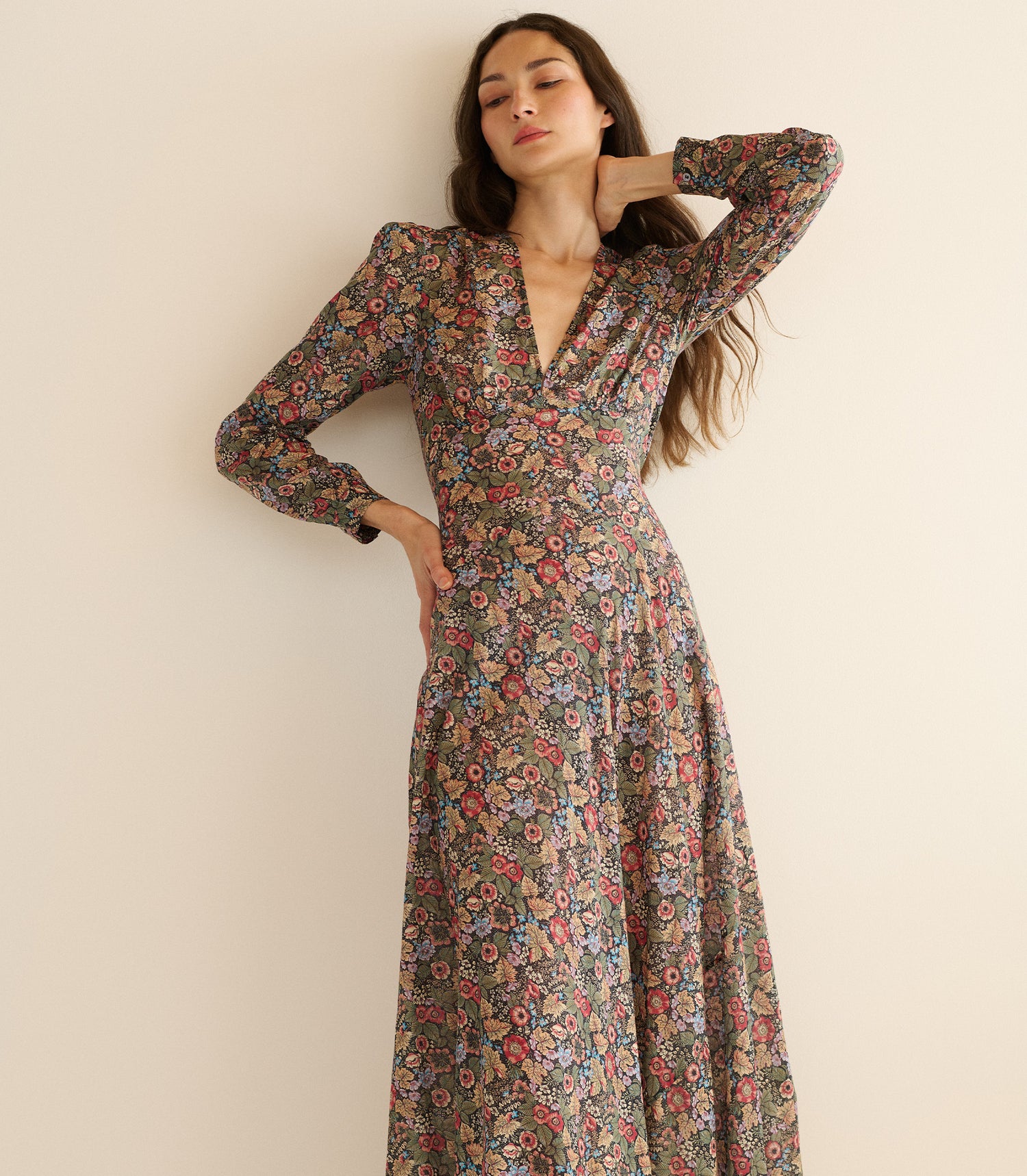 Woman wearing a floral dress against a plain background
