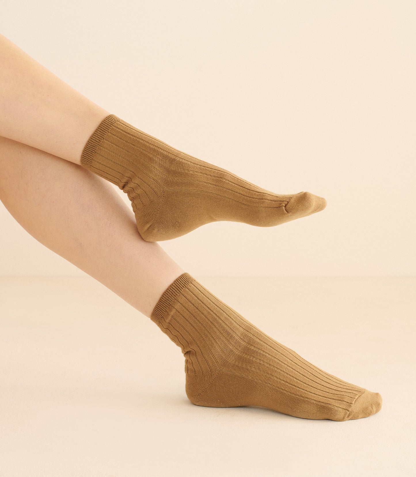 Brown socks worn by a person on a beige background