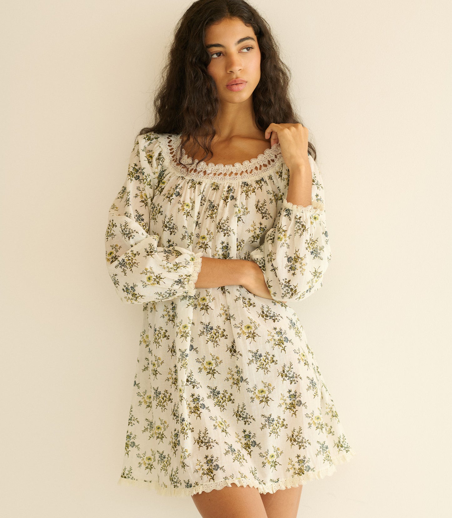 Woman wearing a floral dress against a plain background