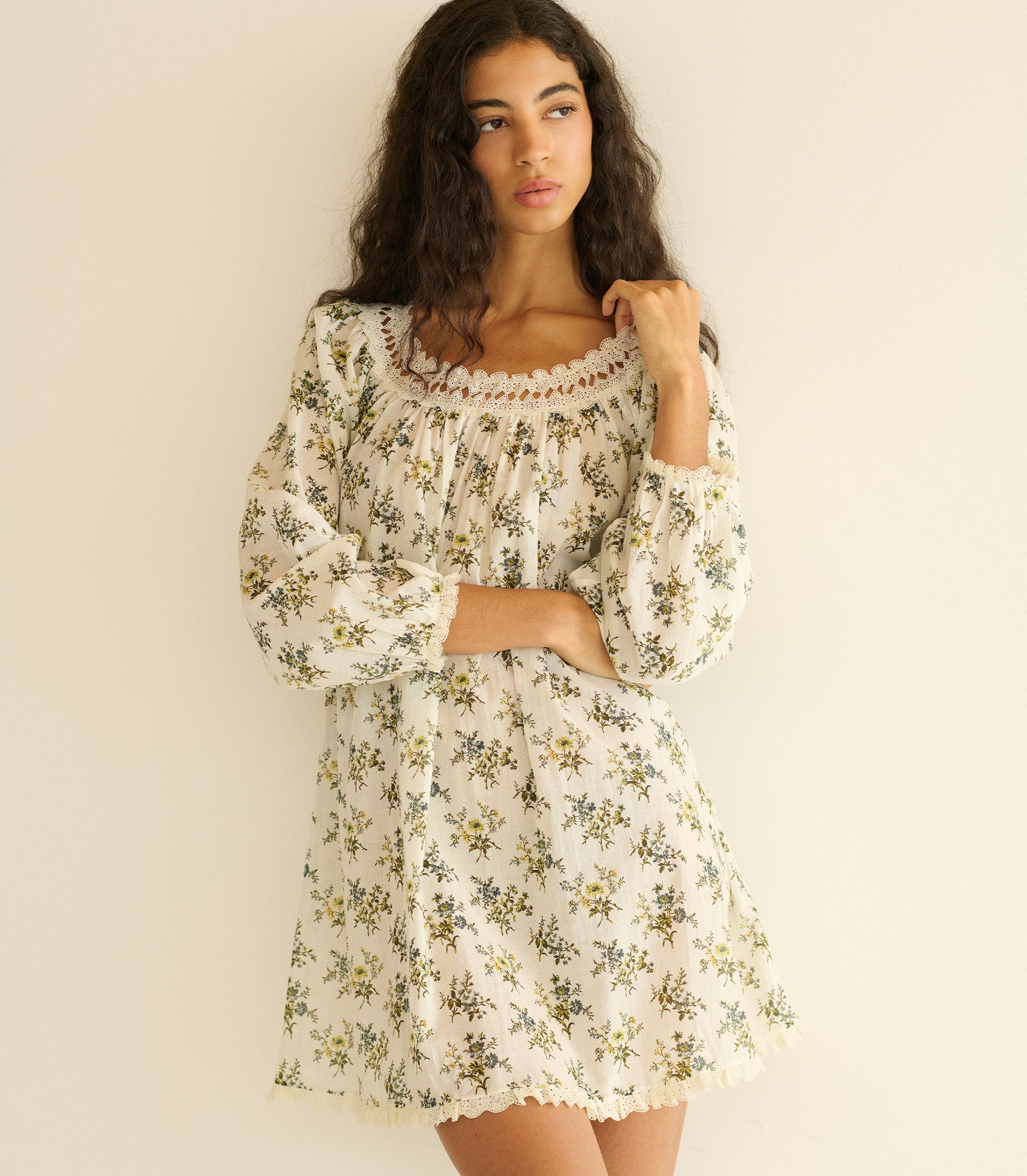 Woman wearing a floral dress against a plain background