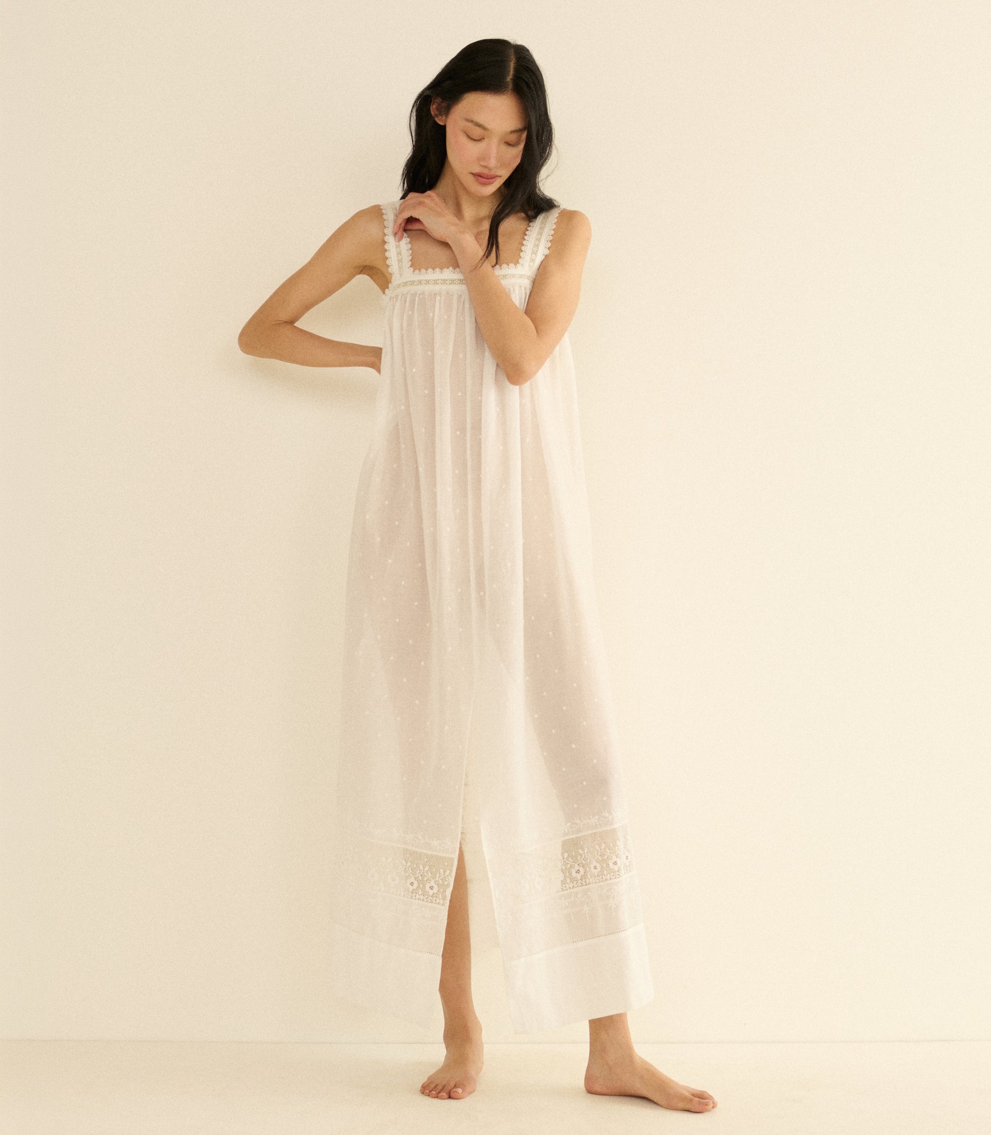 Woman wearing a long, white dress against a plain background 1
