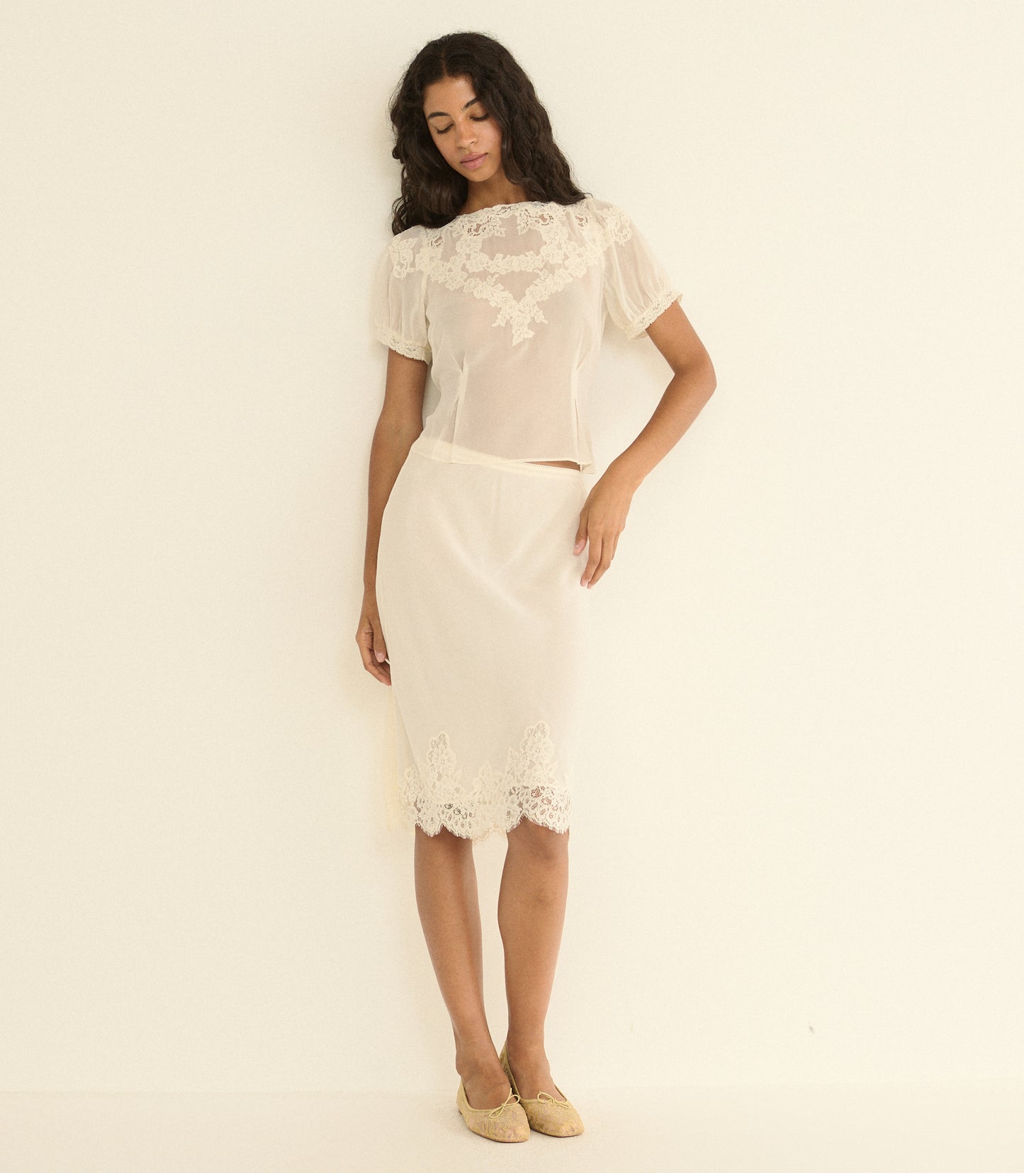 Woman wearing a white skirt outfit on a plain background