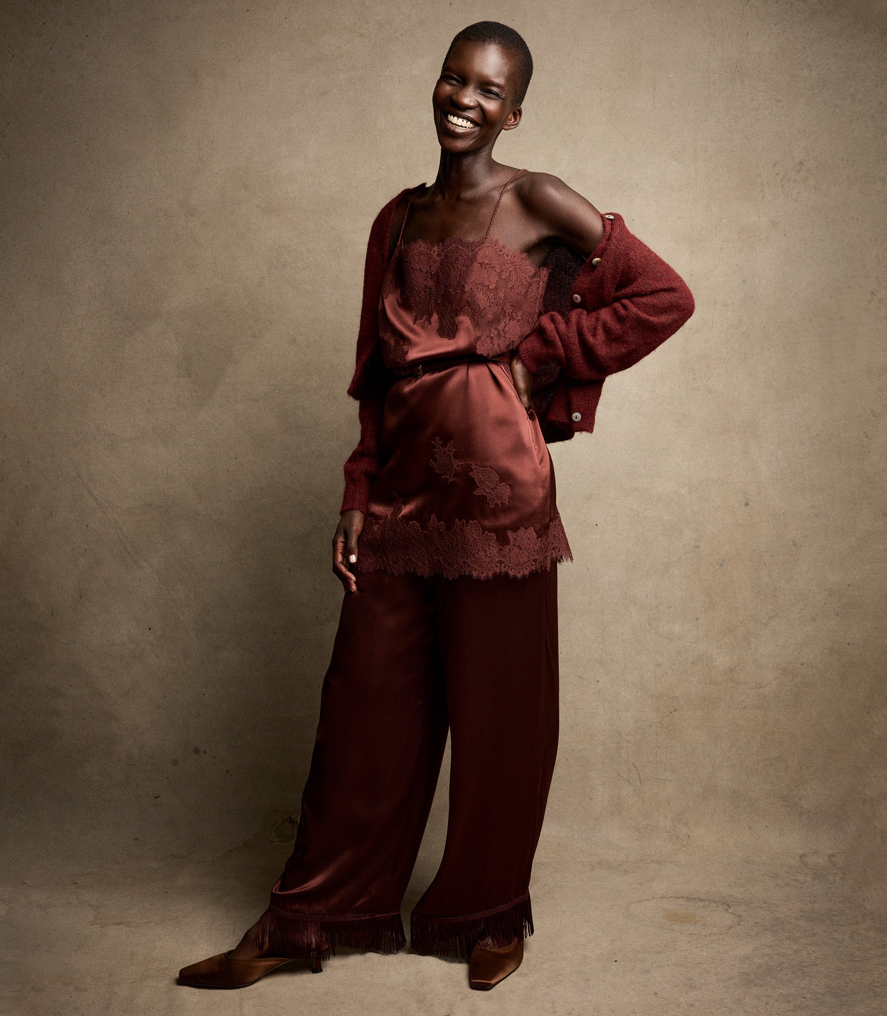 Person wearing a burgundy outfit against a beige background 1
