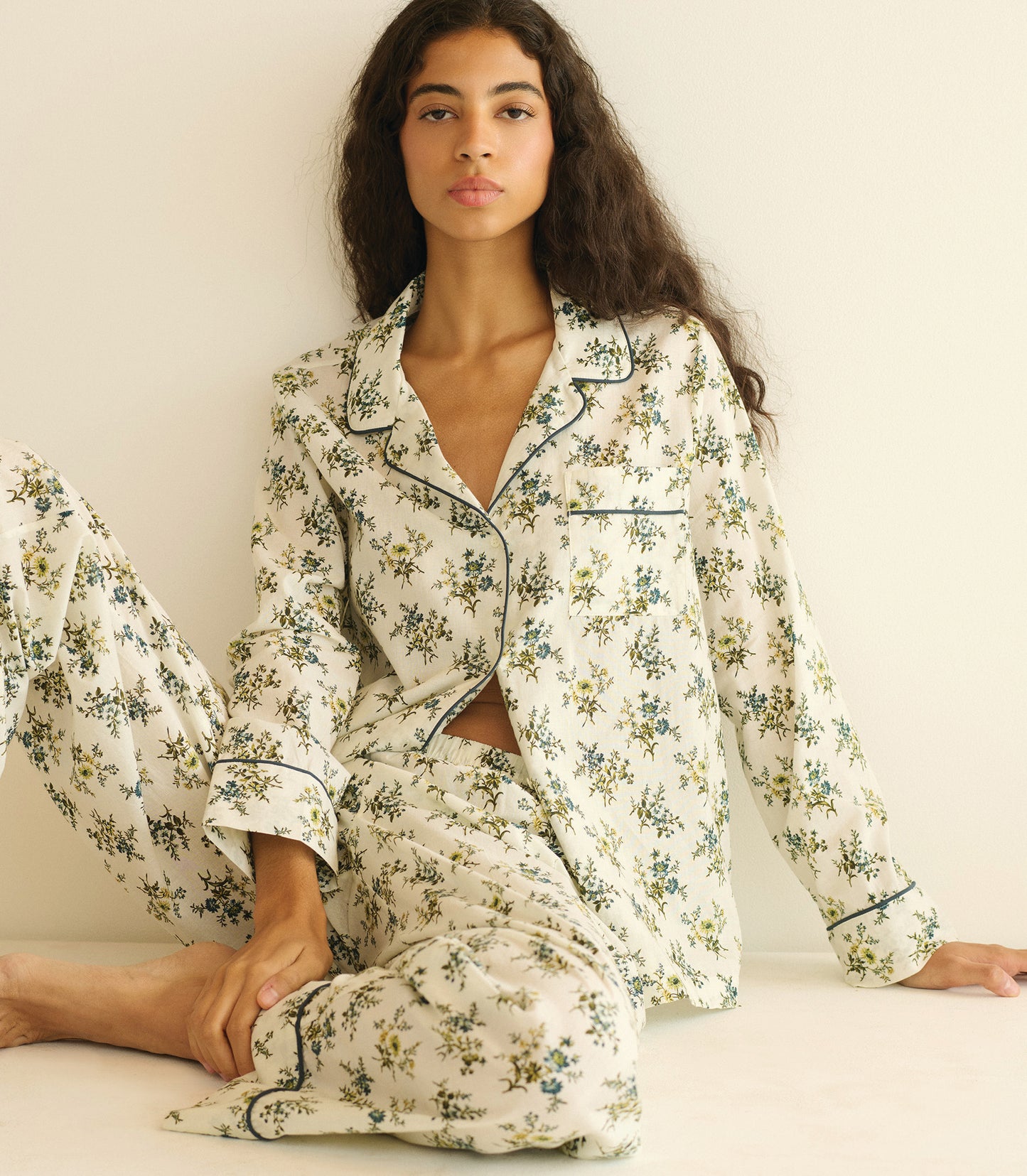 Woman wearing a floral pajama set on a white background