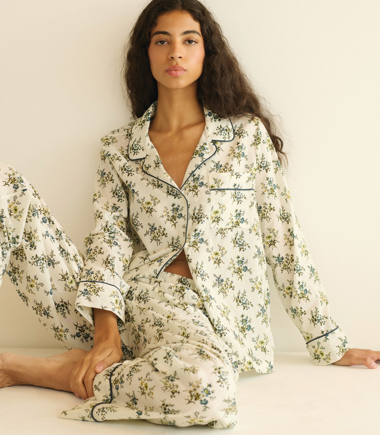 Woman wearing a floral pajama set on a white background