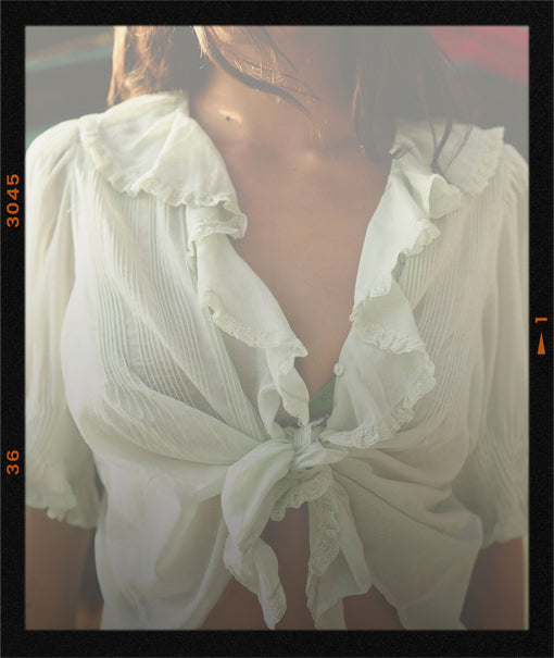 Ruffled blouse worn by a person with a blurred background