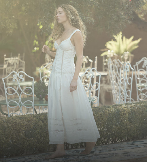 Woman in a white dress walking in a garden