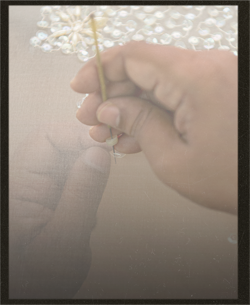 Hand delicately threading with a blurred background