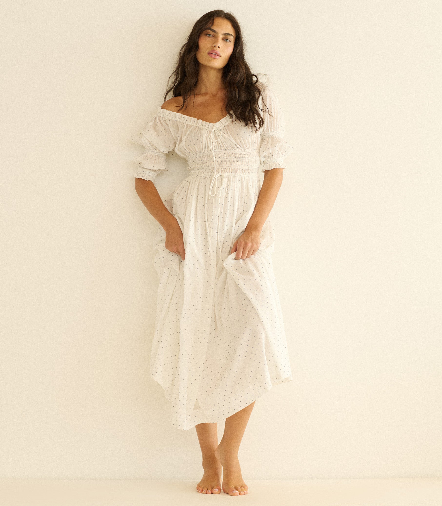 Woman wearing a white dress against a plain background