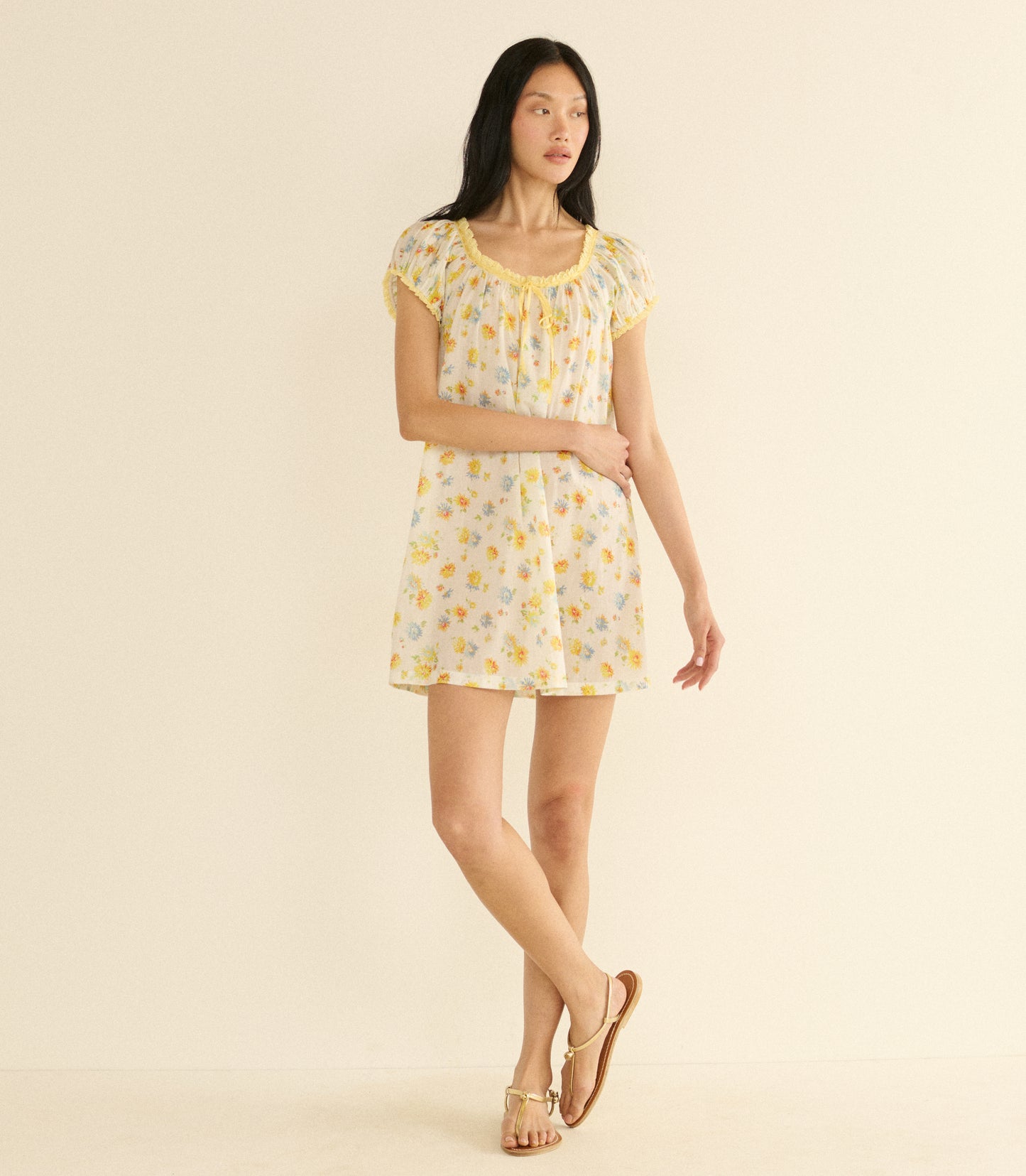 Woman wearing a white floral dress on a beige background