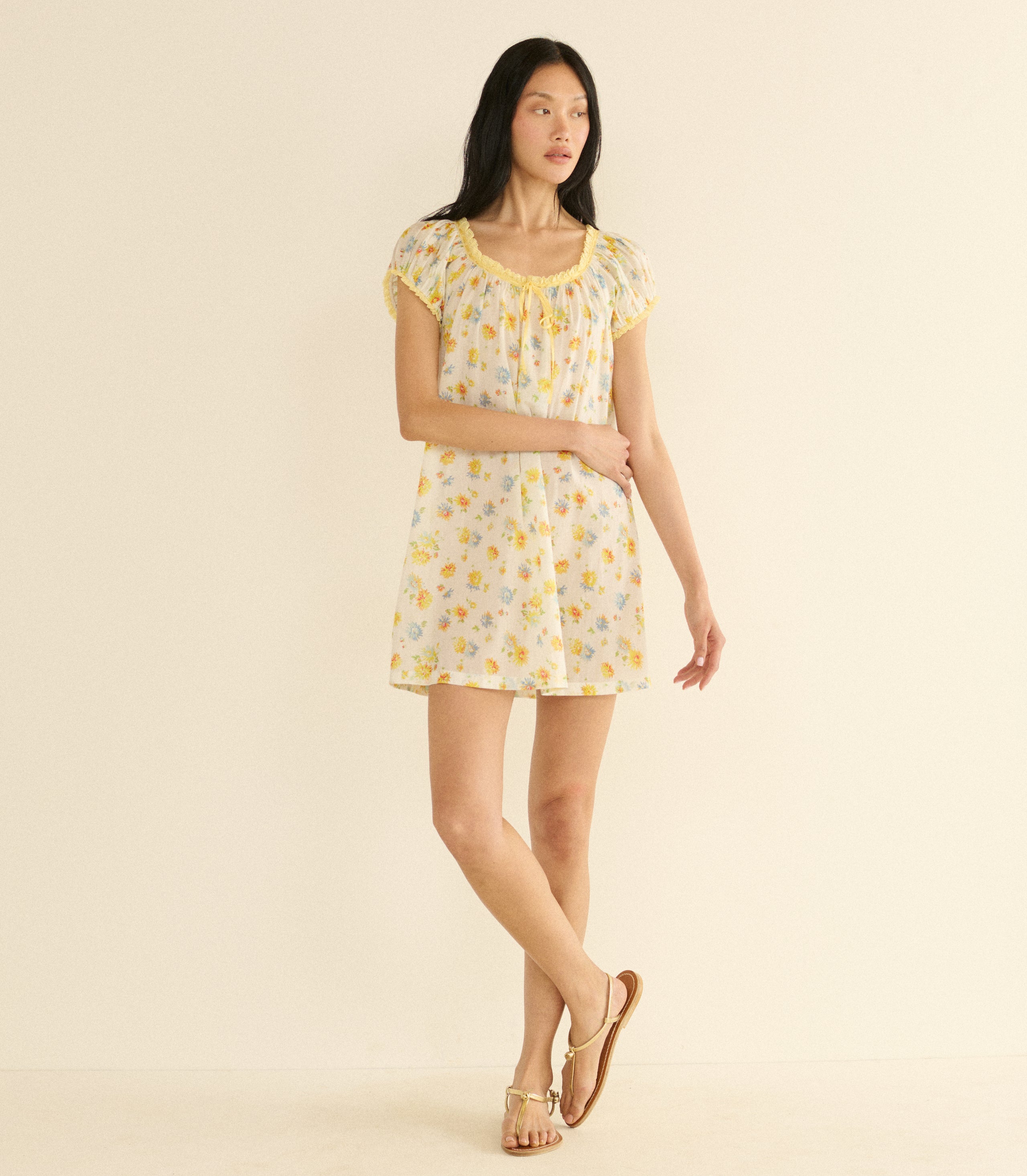 Woman wearing a white floral dress on a beige background
