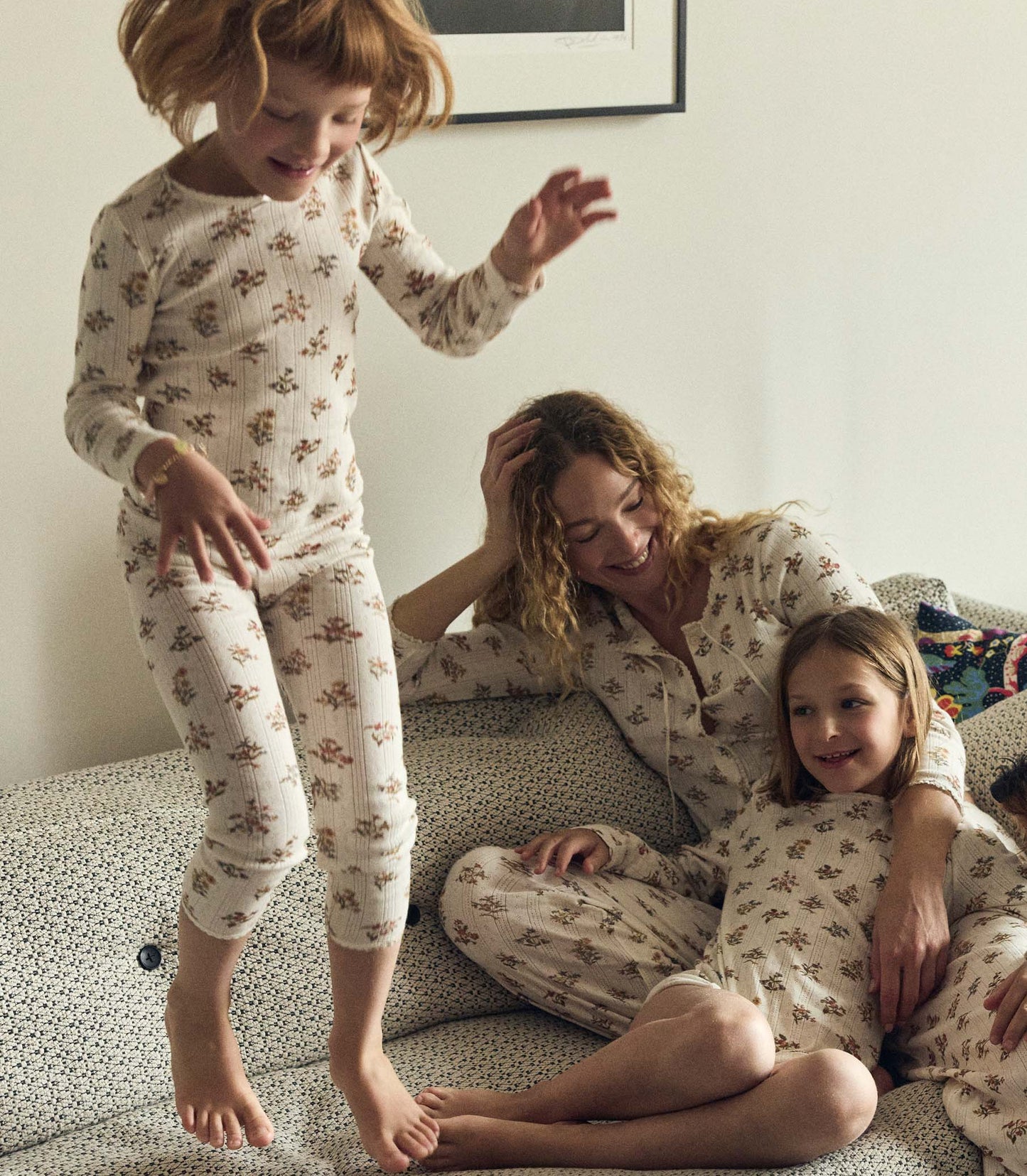 Family in matching floral pajamas on a couch