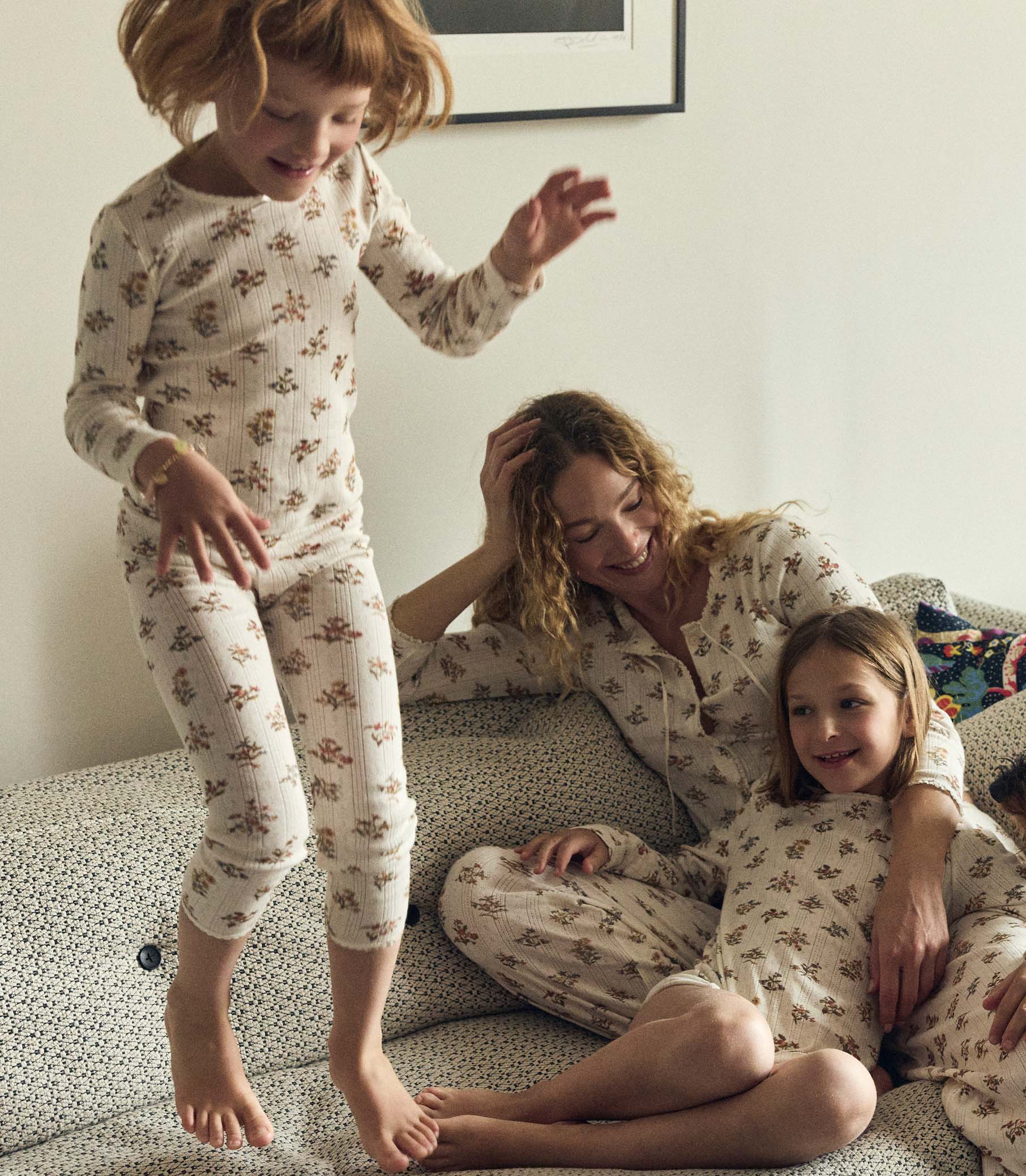 Family in matching floral pajamas on a couch
