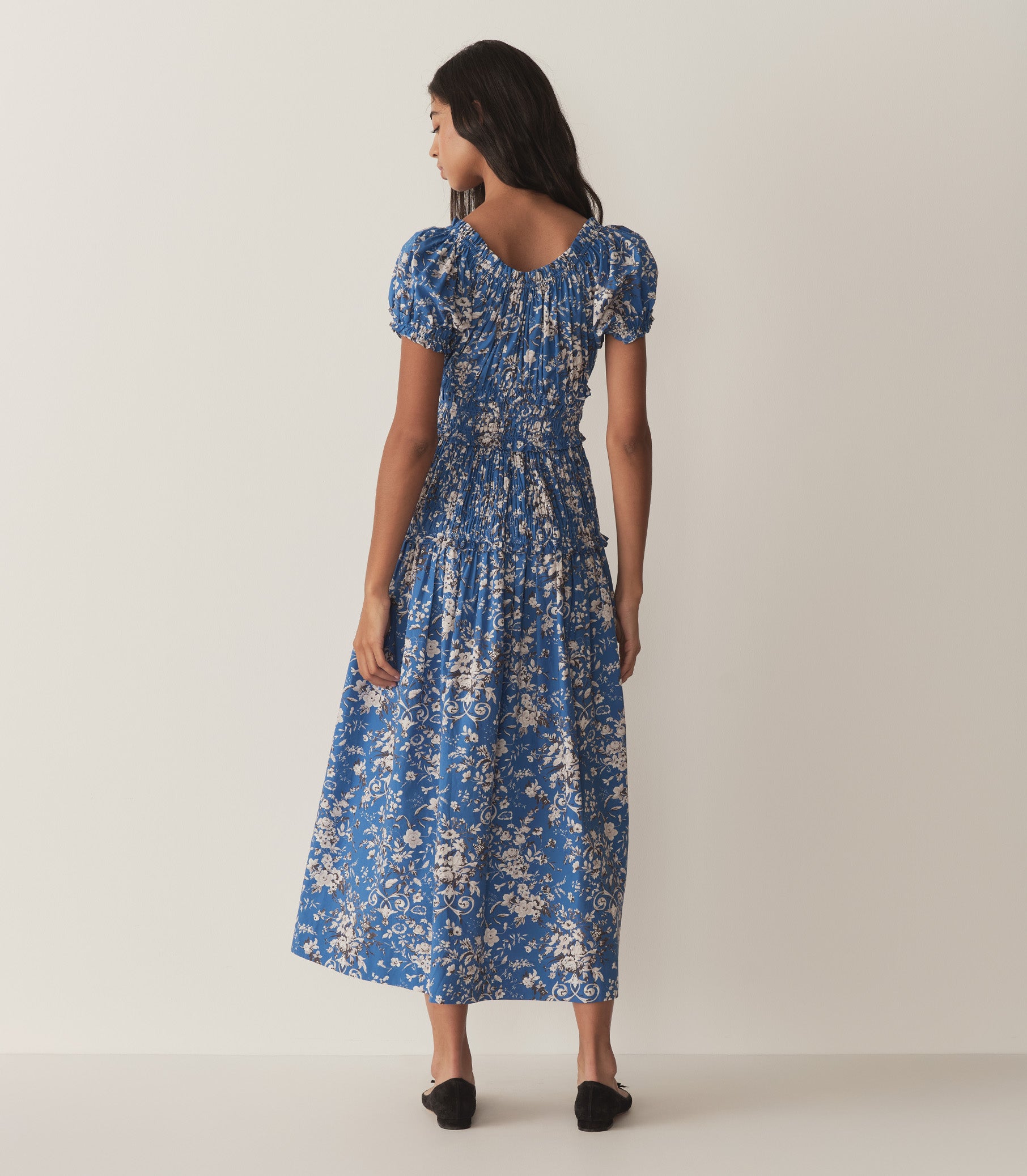 Rocio is wearing a long blue and white floral dress. 3