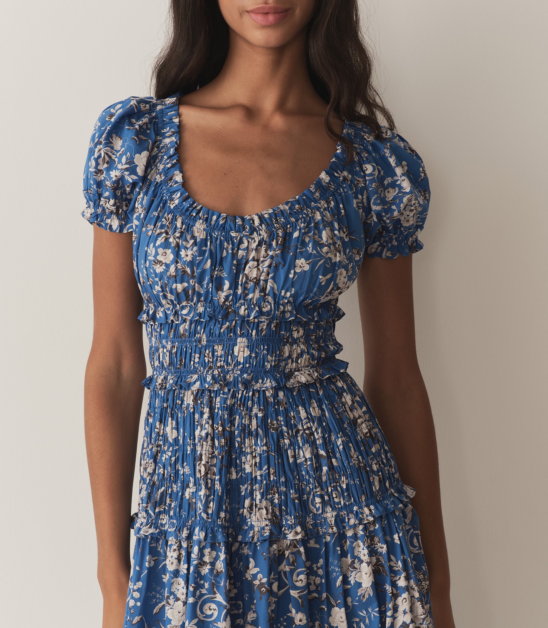 Rocio is wearing a long blue and white floral dress. 2