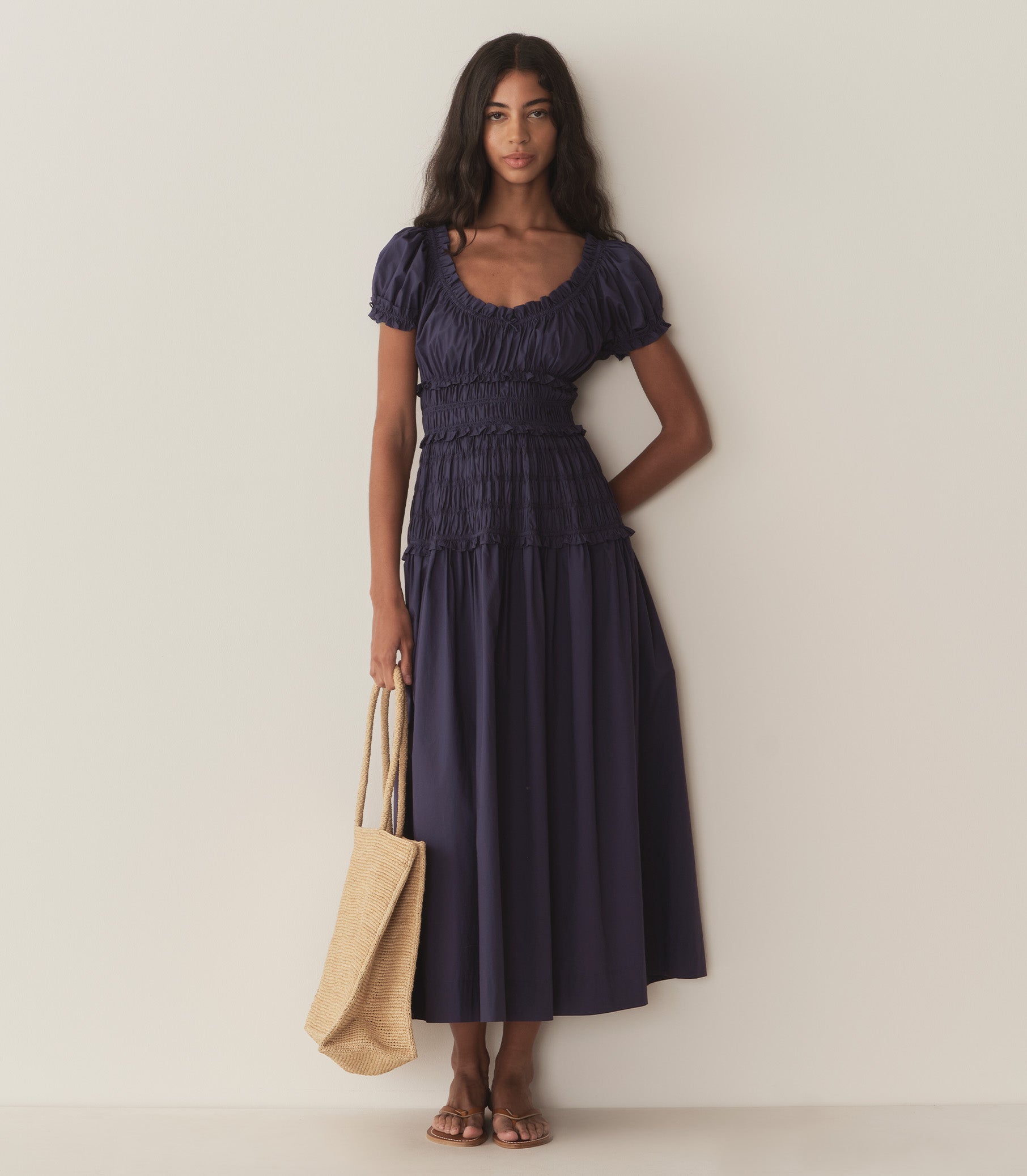 Rocio wears a dark blue dress with puffed sleeve and ruching along the bodice. 5