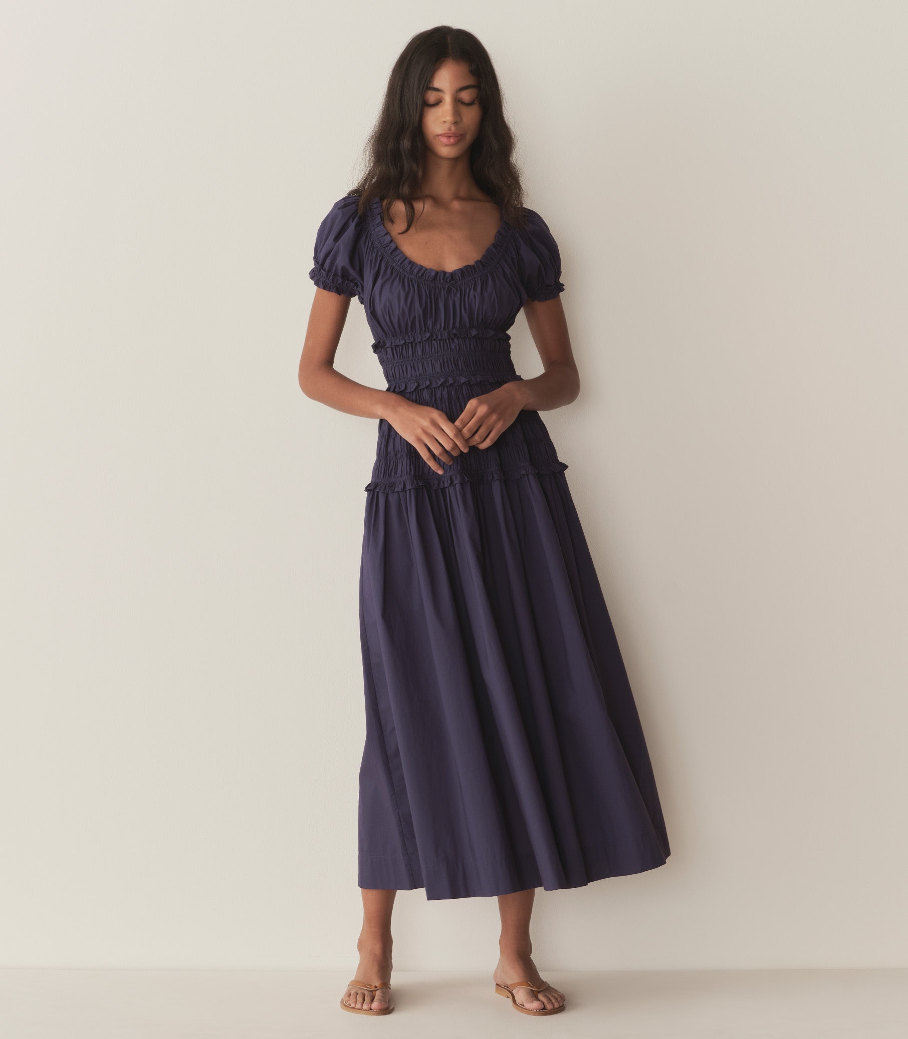 Rocio wears a dark blue dress with puffed sleeve and ruching along the bodice. 4