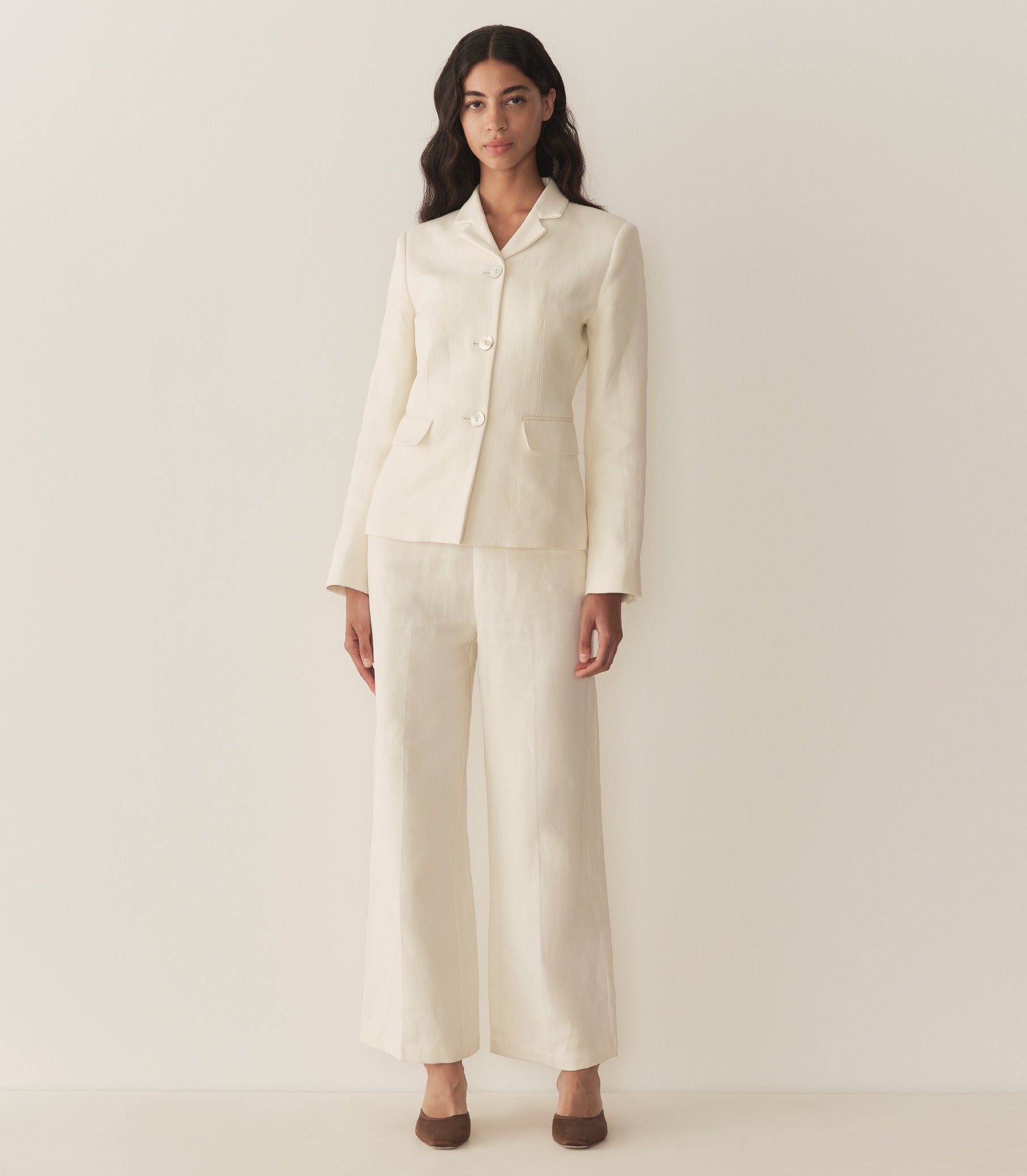 Rocio is wearing an off white blazer paired with its matching pants, a bandana, and brown kitten mules. 4