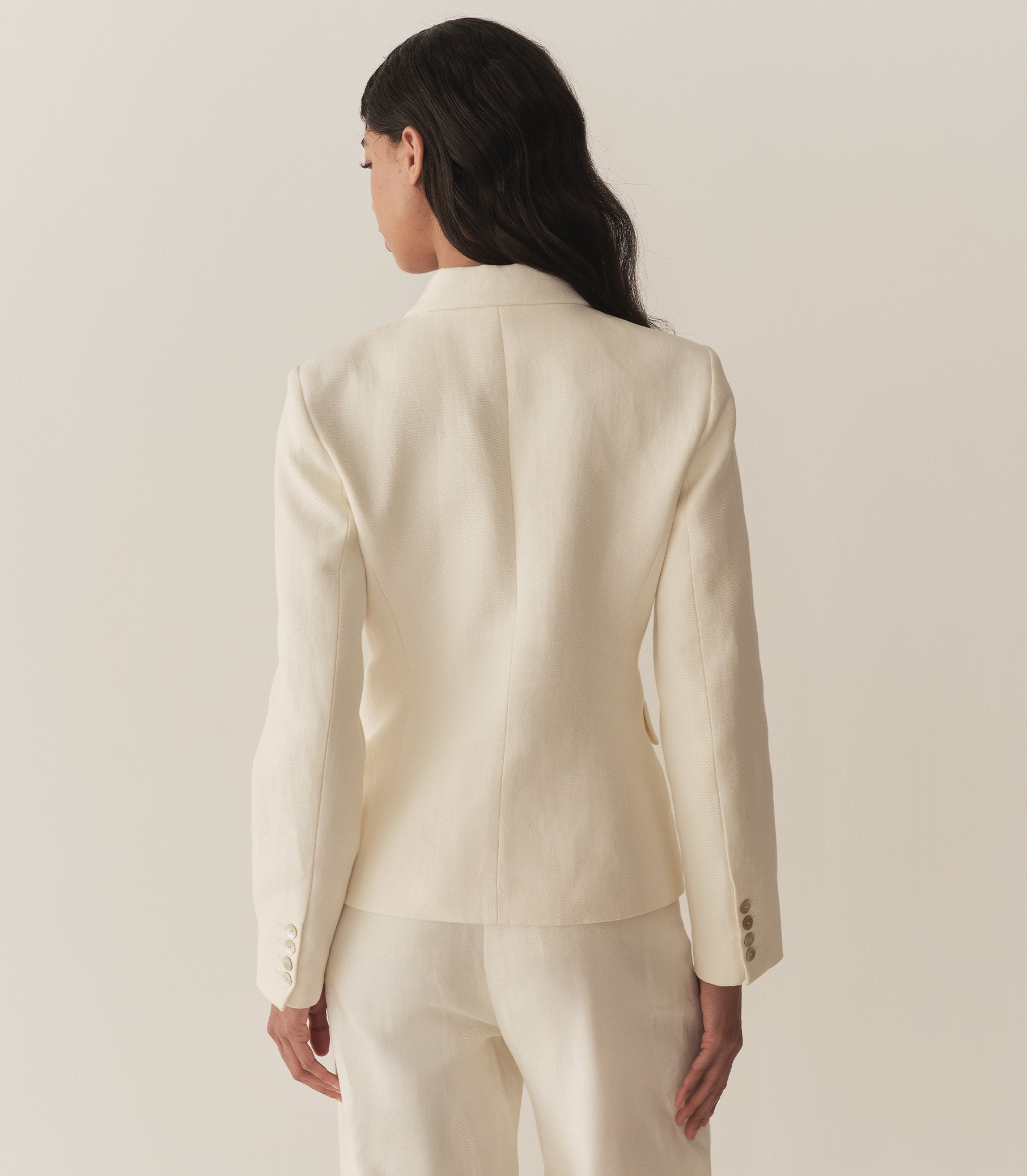 Rocio is wearing an off white blazer paired with its matching pants, a bandana, and brown kitten mules. 5