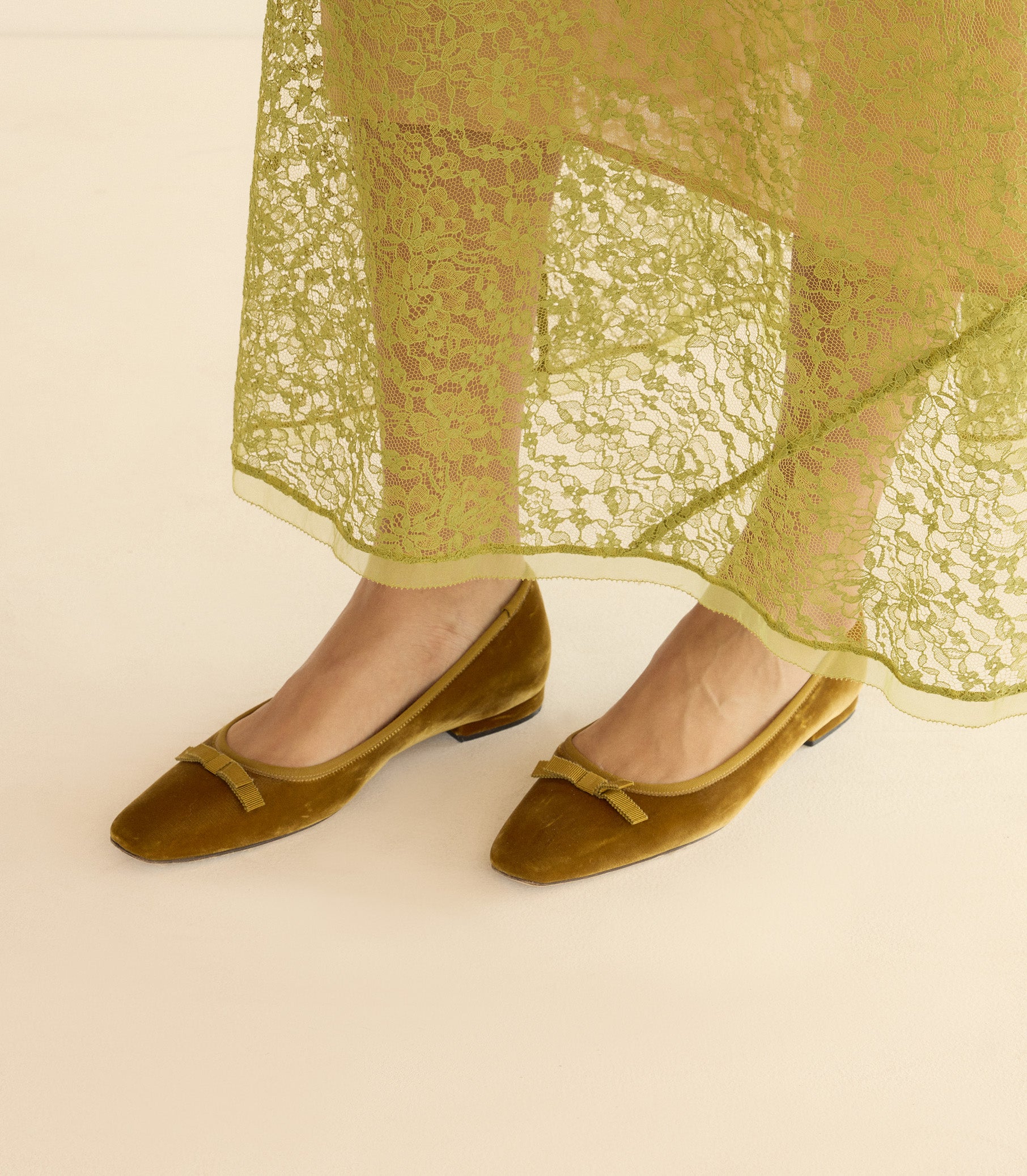 Green lace dress with green shoes on a beige background