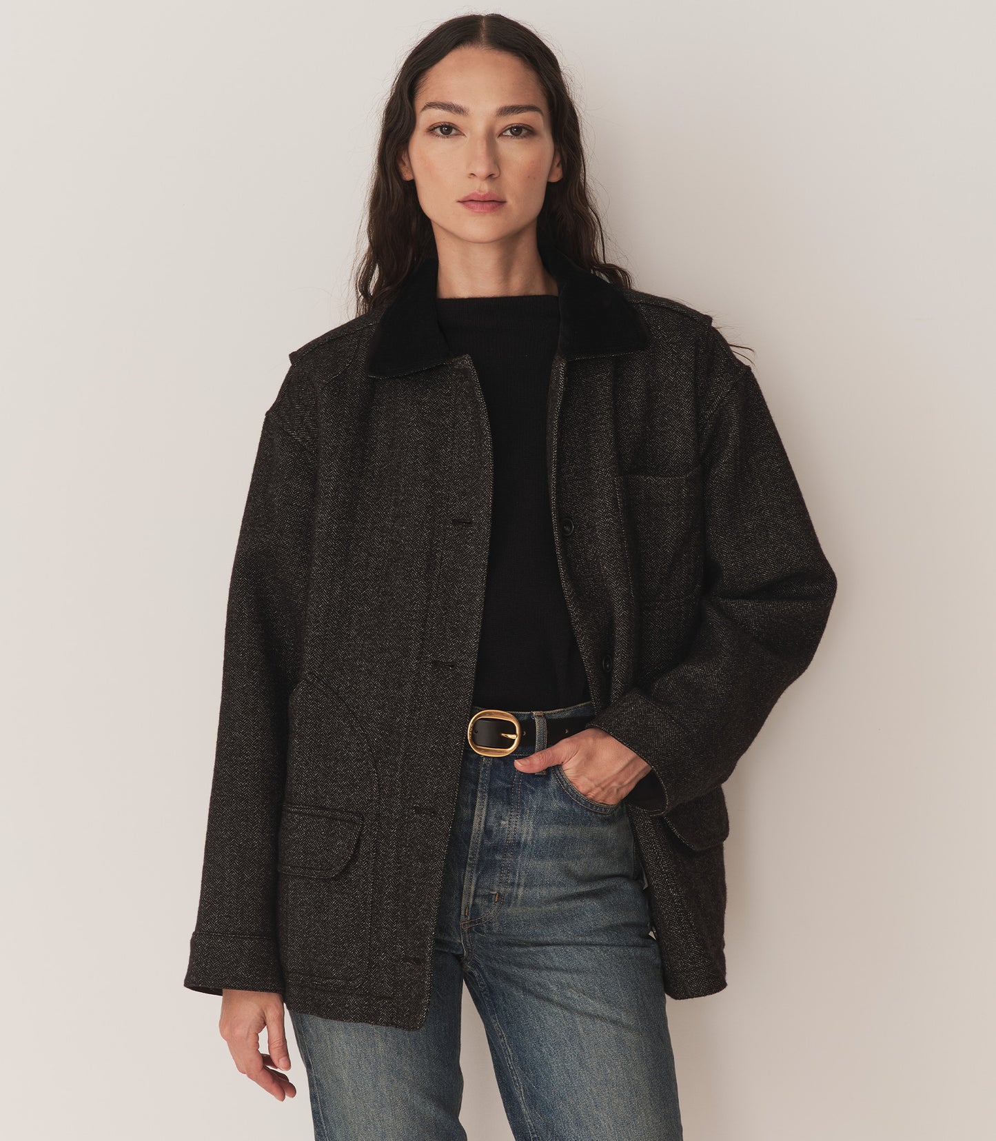 Person wearing the Pascual Wool Jacket in Charcoal Herringbone with blue jeans and a black belt.