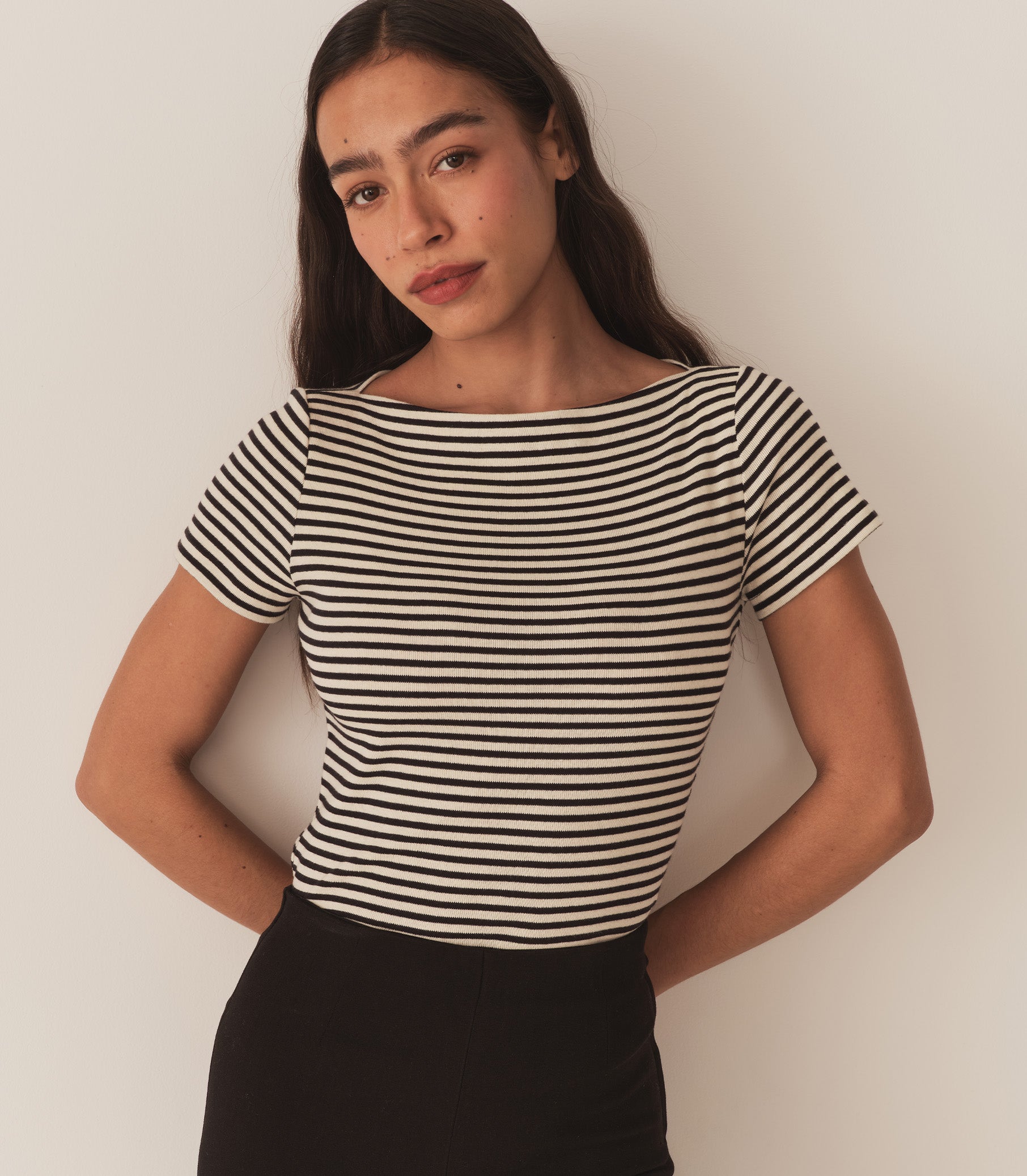 Zahara wears a black and white striped tee with black pants. 1