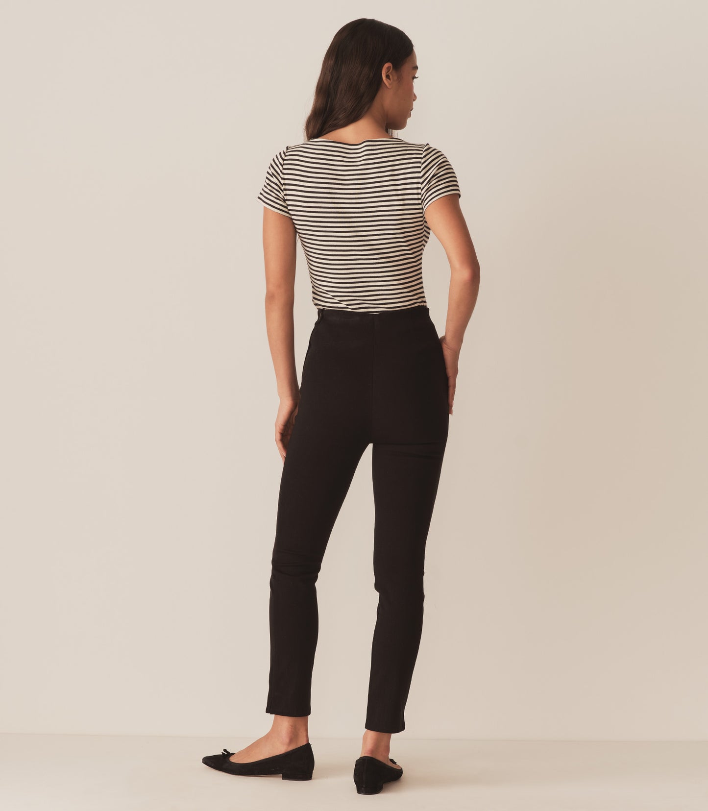 Zahara wears a black and white striped tee with black pants.