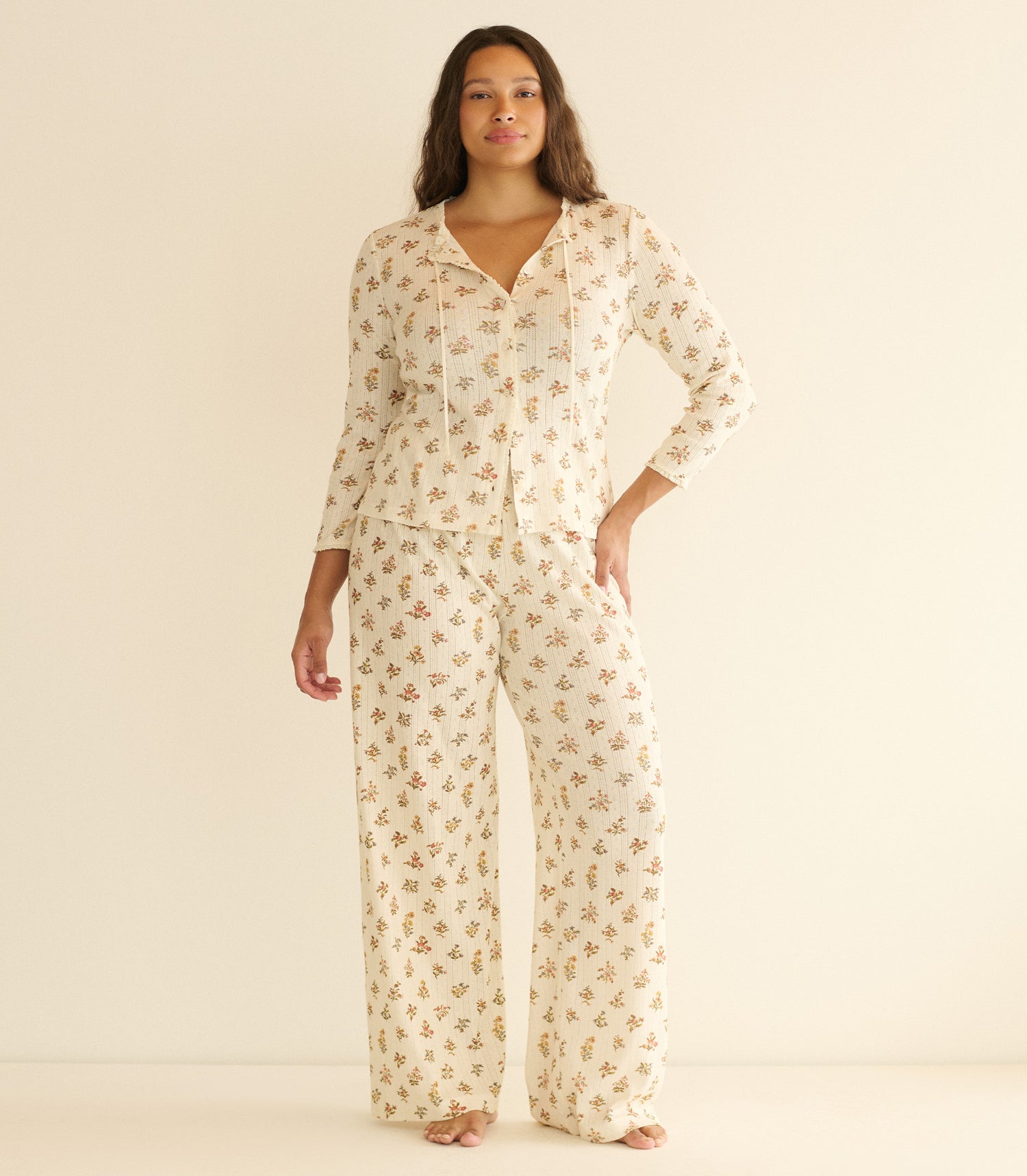 Woman wearing a floral pajama set on a beige background