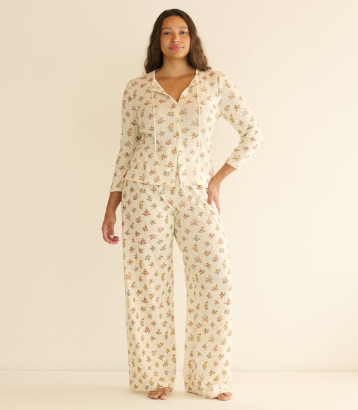 Woman wearing a floral pajama set on a beige background