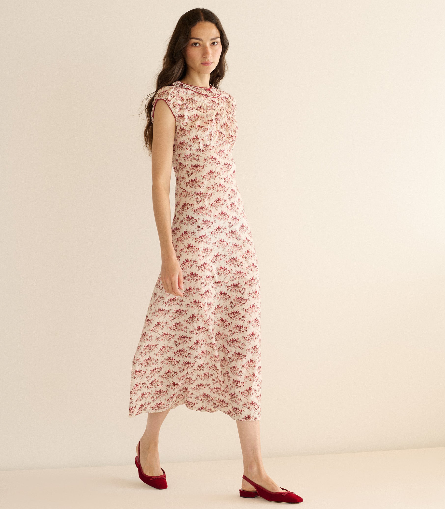 Woman wearing a floral dress on a plain background 1