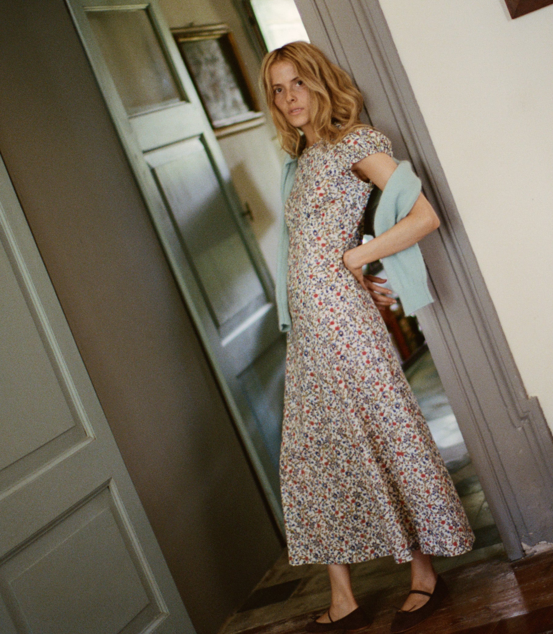 Woman in a floral dress standing in a doorway