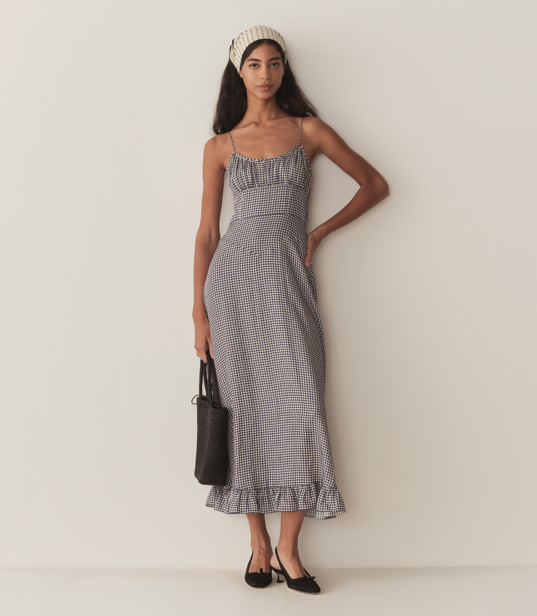 Rocio wears the blue gingham Rosaria Dress.