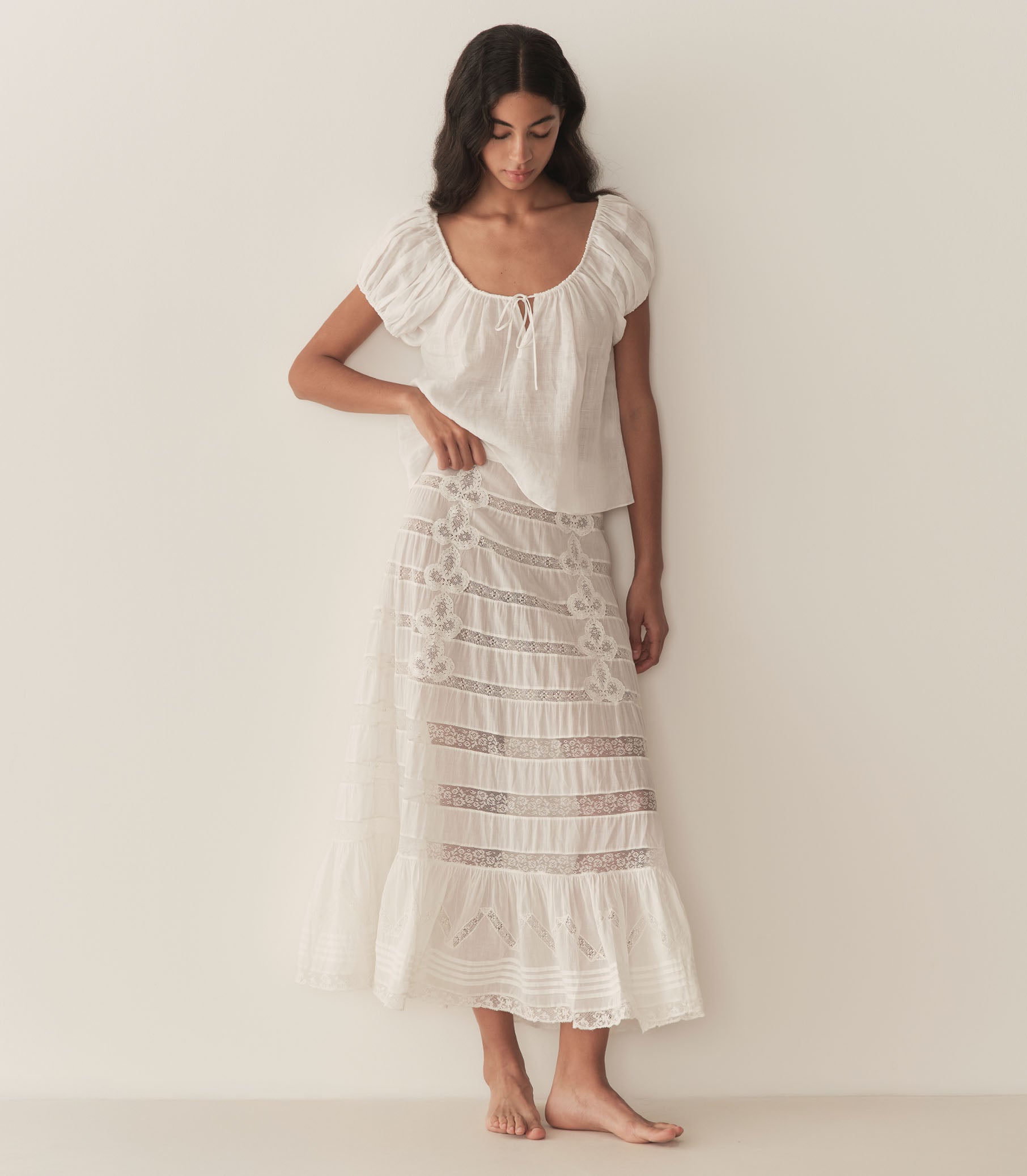 Rocio is wearing a white short puff sleeve blouse paired with a white maxi skirt. 3